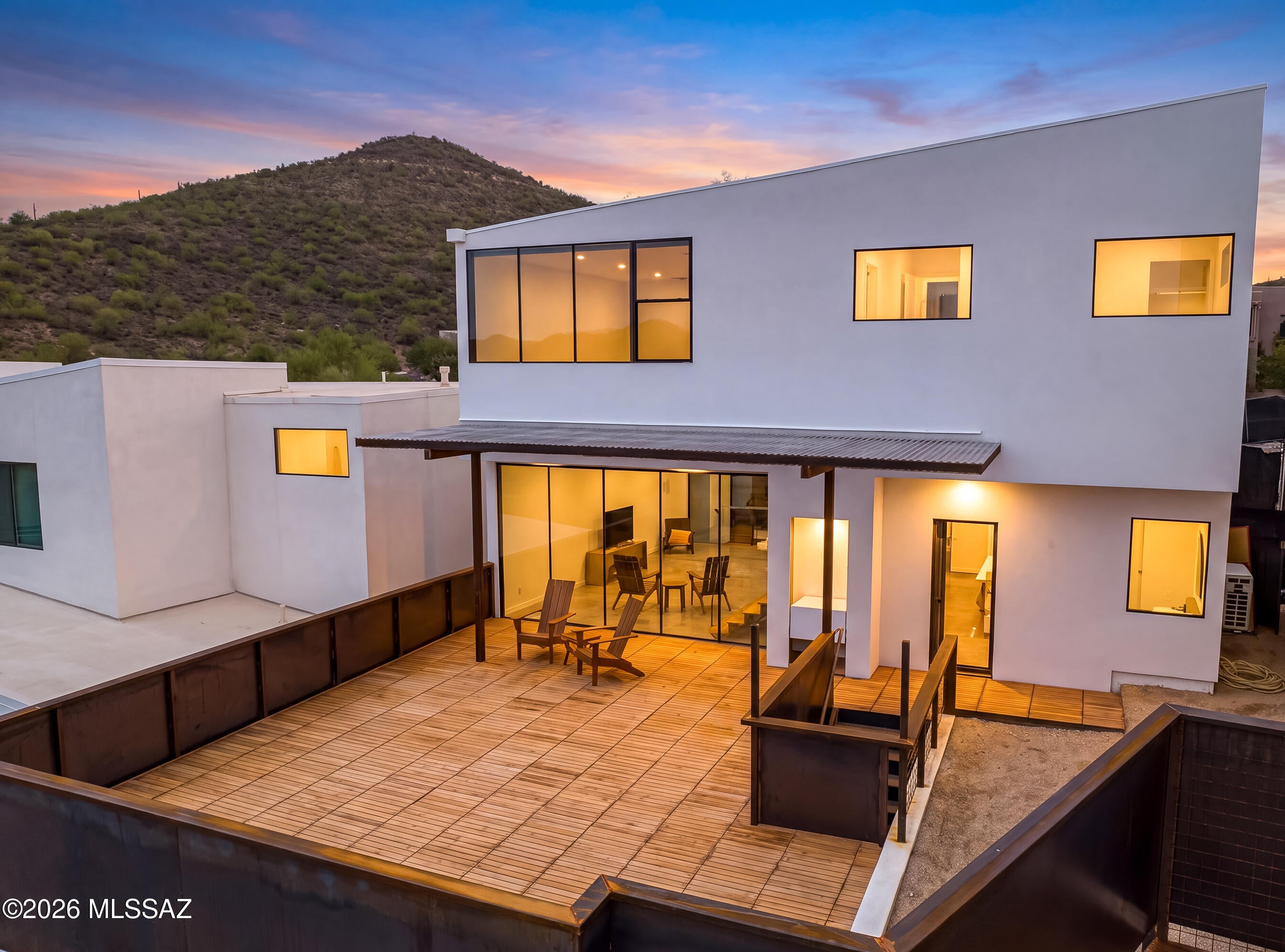 A home where every view becomes part of the design. Perched high above the city in Sentinel Vista, this custom modern residence was thoughtfully positioned to capture panoramic views of the Catalina Mountains, sparkling city lights, and unforgettable Arizona sunsets. Expansive floor-to-ceiling glass fills the home with natural light while creating a seamless connection between the indoors and the surrounding landscape. A spacious teak deck with custom metal accents offers the perfect setting to unwind or entertain against Tucson's breathtaking backdrop. One of only 11 architecturally distinct homes in this exclusive hillside community, this residence offers modern design, premium finishes, and a lifestyle that's anything but ordinary. Additional lots and floor plans are available.
