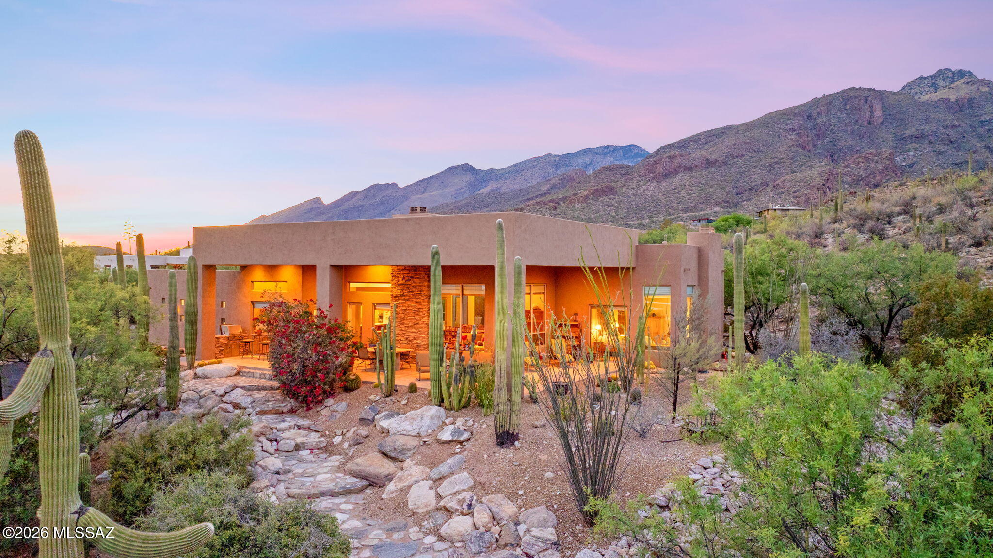 Discover a truly distinctive desert retreat in the heart of Tucson's prestigious Catalina Foothills at 6342 N Sabino Shadow Lane. Set on approximately one acre and surrounded by the natural beauty of the Sonoran Desert, this unique three-bedroom, two-bath residence offers an exceptional combination of privacy, dramatic views, abundant natural light and comfortable, low-maintenance living. From the moment you enter the home, the setting immediately makes an impression. Three expansive viewing windows frame a picturesque mountain backdrop, creating a stunning focal point and bringing the beauty of the desert landscape directly into the home. Throughout the property, sweeping mountain and city views complement the private surroundings and reinforce the feeling of a secluded Arizona retreat. The interior is defined by polished concrete floors, immense natural light and a comfortable, functional floor plan designed for effortless everyday living and entertaining. The spacious living room is anchored by a fireplace and oriented to capture the surrounding views, while a second fireplace in the primary bedroom adds warmth and character to the private owner's retreat.

The generously sized primary ensuite offers exceptional comfort with a large walk-in closet, spacious shower and separate soaking bathtub. Additional living areas provide flexibility while maintaining an open and inviting feel throughout the residence.

A three-car garage provides excellent parking and storage, while a separate dedicated storage room offers tremendous versatility and could easily serve as a wine room, oversized pantry, additional household storage or specialty space depending on the buyer's needs.

Outdoor living is enhanced by the privacy and scale of the approximately one-acre homesite, creating a peaceful setting where desert vegetation, mountain scenery, city lights and open skies become part of the everyday experience. The property is particularly appealing for buyers seeking a home that embraces the Tucson lifestyle without the demands of extensive maintenance.

Adding to the opportunity is the potential to purchase the adjacent vacant parcel of nearly one acre, creating the possibility of an even larger private desert compound, expanded outdoor living space or simply additional separation and privacy.

Ideally located near Sabino Canyon, Ventana Canyon, hiking, golf, shopping, dining and the amenities of the Catalina Foothills, the home also enjoys access to the highly regarded Catalina Foothills School District.

6342 N Sabino Shadow Lane is a rare offering for the buyer seeking something beyond the ordinary--a private desert sanctuary with exceptional natural light, striking mountain and city views, architectural character and the opportunity to create an even more expansive Arizona retreat.