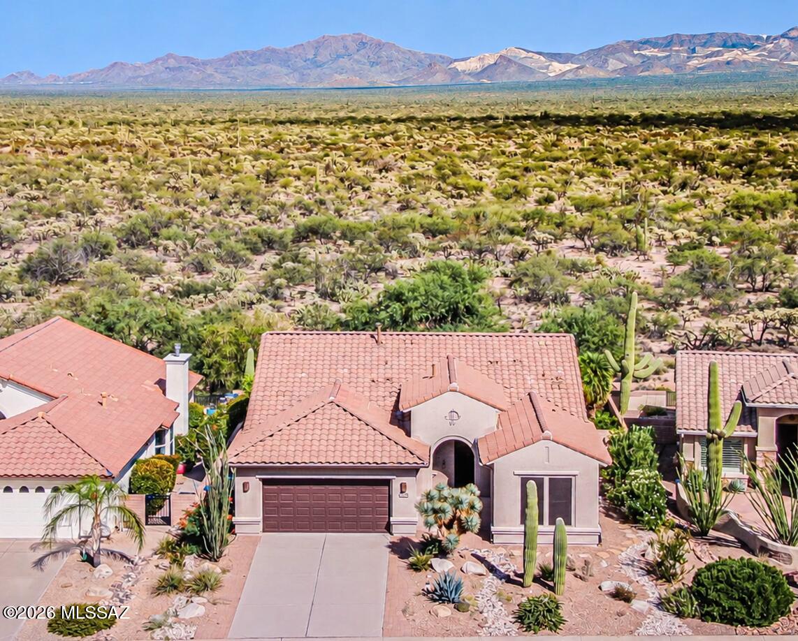 PANORAMIC VIEWS, DESERT PRIVACY & A PREMIUM LOT! Enjoy Mountain and desert views from this beautifully positioned home bordering the Santa Rita Experimental Range. With untouched desert as its backdrop, the property offers exceptional privacy, peaceful surroundings, abundant wildlife, and stunning scenery that stretches for miles. Filled with natural light, this approximately 1,848-square-foot home features three bedrooms, two bathrooms, and an inviting open-concept floor plan designed to showcase the views. A brand-new roof installed in 2024 provides added peace of mind. Interior highlights include ceramic tile throughout the main living areas, luxury plank flooring in the bedrooms, plantation shutters, a cozy gas fireplace, and expansive windows framing the surrounding mountains and and desert. The spacious kitchen is the heart of the home, offering abundant cabinetry, granite countertops, stainless steel appliances, and a generous breakfast bar that opens to the living and dining areas, perfect for entertaining or comfortable everyday living. The split-bedroom layout provides privacy for guests, and the flexible third bedroom can also serve as a den or home office. The spacious owner's suite enjoys beautiful views and includes dual sinks, a walk-in shower, and a walk-in closet. Step outside to your private backyard retreat and unwind in the saltwater spa while taking in colorful sunsets, peaceful desert mornings, and unforgettable Arizona views. Homes with this level of privacy, scenery, and connection to the natural desert landscape rarely become available!