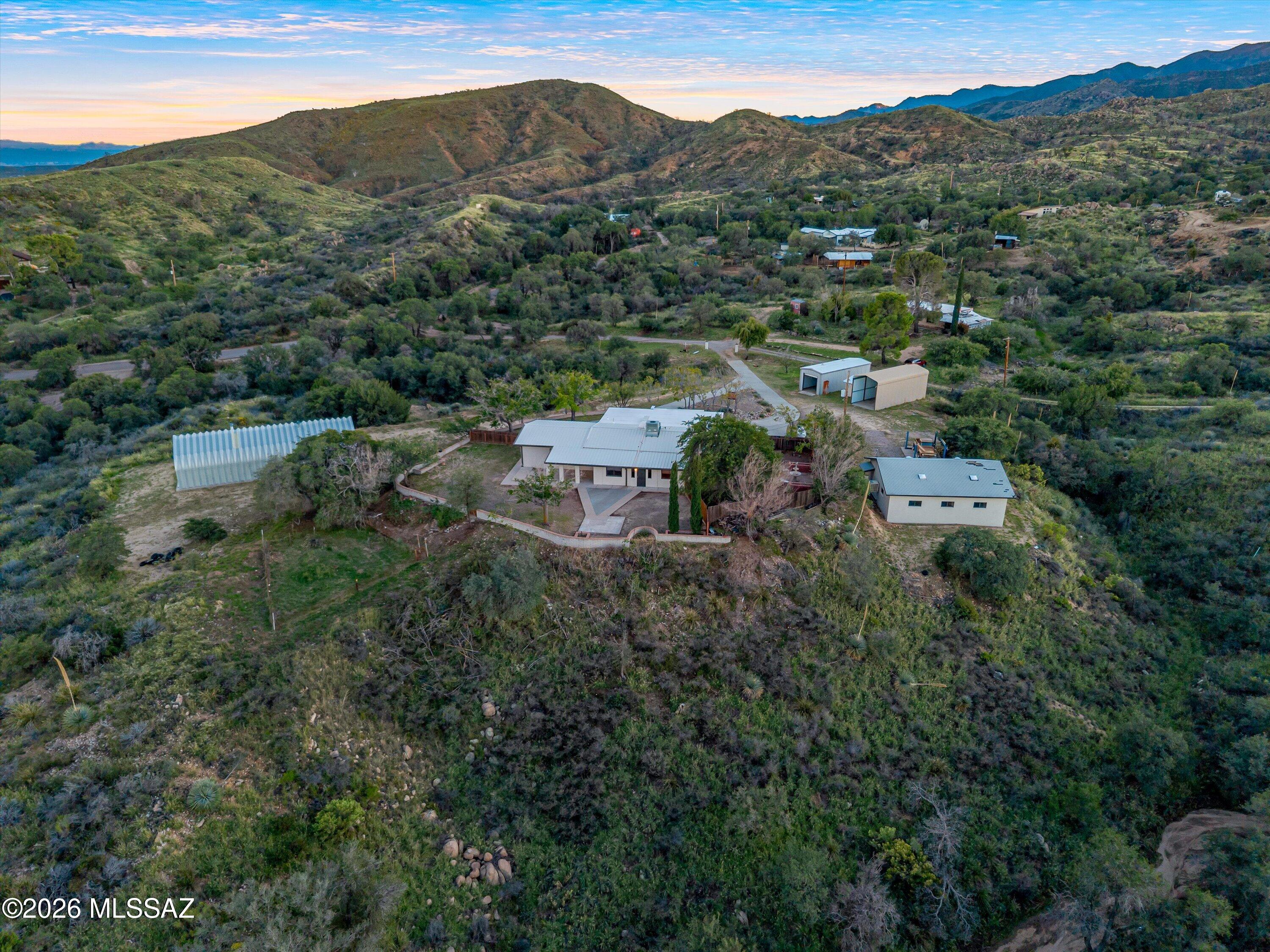 8.5 acres of horse property in the peaceful hills of Oracle, with a private well and panoramic views. Attached 2-bay garage along with separate 3-bay garage, plus 2 huge stand-alone metal garages and an RV carport provide ample workspace and vehicle/toy storage. Enjoy sunrises, sunsets and the surrounding natural beauty from the fenced-in backyard and courtyard, with immense privacy. The interior features 2 bedrooms and a 3rd bonus room for flexible living arrangements, with a separate family room. Immerse yourself in the gorgeous acreage, with walking trails throughout the property and a variety of lookouts to take in the surrounding wildlife & mountain views. Propane tank & Generac back-up generator for off-grid potential! Find privacy and peace in the charming town of Oracle, AZ.