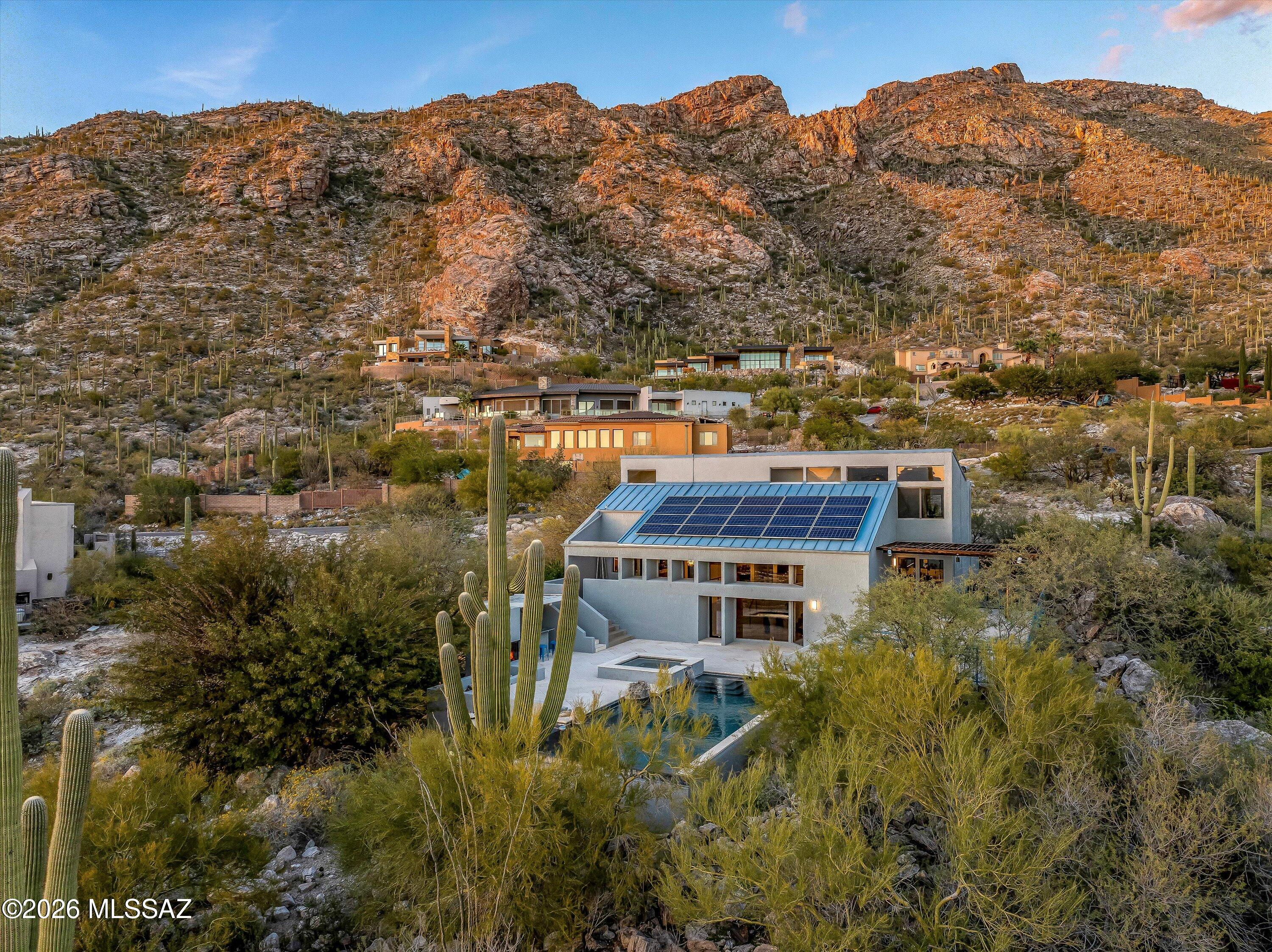 At ''The Top of Swan'' in Coronado Foothill Estates, this rare 1+ acre hillside gem that features 360° views, incredible natural light, and indoor-outdoor living with an updated take on 1970s architecture. Travertine floors anchor a modern interior with a chef's kitchen featuring a Thermador range and top-rated LG appliances. The primary suite offers a private north-facing balcony with Catalina views. Apple HomeKit controls lighting, HVAC, shades, locks, and pool/spa jets. Outside features an infinity pool and spa, an expansive patio with a fireplace and bar, perfect for desert entertaining with sunset views over the City of Tucson and the Tucson Mountains. With 3 bedrooms and 2.5 baths, this home was designed to be lived in - plus a detached garage/shop for gearheads.