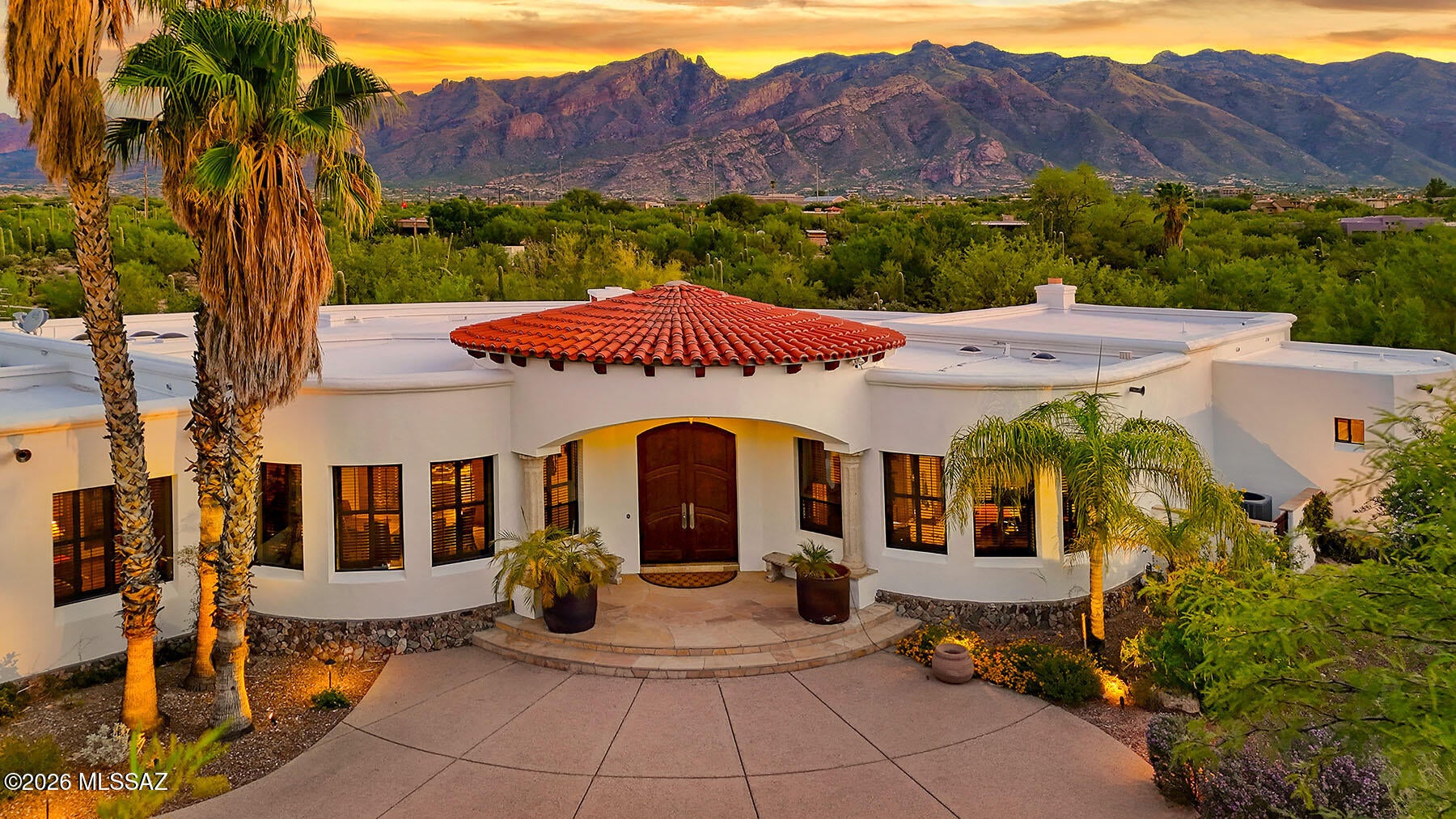 ONE-OF-A-KIND SOUTHWESTERN CONTEMPORARY ESTATE IN THE CATALINA FOOTHILLS! Set behind private gates on 1.49 acres of southwestern desert, saguaros, cacti, mesquite and palo verde trees, with stunning Catalina Mountain views, this extraordinary property offers privacy, architectural distinction, and an exceptional connection to the Sonoran Desert. Custom designed and built by acclaimed local architect/designer Al Gastelum of Centerline Design & Interiors, the approximately 4,534 sq ft main residence showcases impeccable craftsmanship, ICF concrete construction, solid 8' knotty Alder doors, travertine and scored concrete floors, Venetian plaster, cantera and slate stone, and custom ironwork throughout. The dramatic rotunda entry opens to elegant living and dining spaces, while expansive windows capture the mountain views. The gourmet kitchen features a Viking 6-burner range, rising exhaust, granite island and counters, custom Alder cabinetry, double ovens, Asko dishwasher, newer GE refrigerator, and large walk-in pantry. The luxurious primary suite features Catalina Mountain views, beehive fireplace, French doors to the deep rear porch, and spa-like bath. Two additional bedrooms share a beautifully designed Jack-and-Jill bath, while a private fourth bedroom/office offers flexibility. Outdoor living is exceptional, with deep covered and flagstone porches, beehive fireplace, grilling area, lush landscaping, custom iron fencing, and a private pool with waterfall feature. A separate 770 sq ft guest house/casita offers a fireplace, kitchenette, full bath, custom Murphy bed, private gated yard, and porch. The oversized 963 sq ft three-car garage provides abundant storage. Recent improvements include exterior paint and roof coating (2024), new exterior lighting and cameras, updated irrigation, new turf, and HVAC systems and water heaters (2019). Ideally located near Swan/Sunrise, shopping, dining, Sabino Canyon, Ventana Canyon, trails, parks, and schools, yet offering a remarkably private and peaceful setting. A truly exceptional Tucson estate--beautifully crafted, deeply private, and designed to become a family legacy.