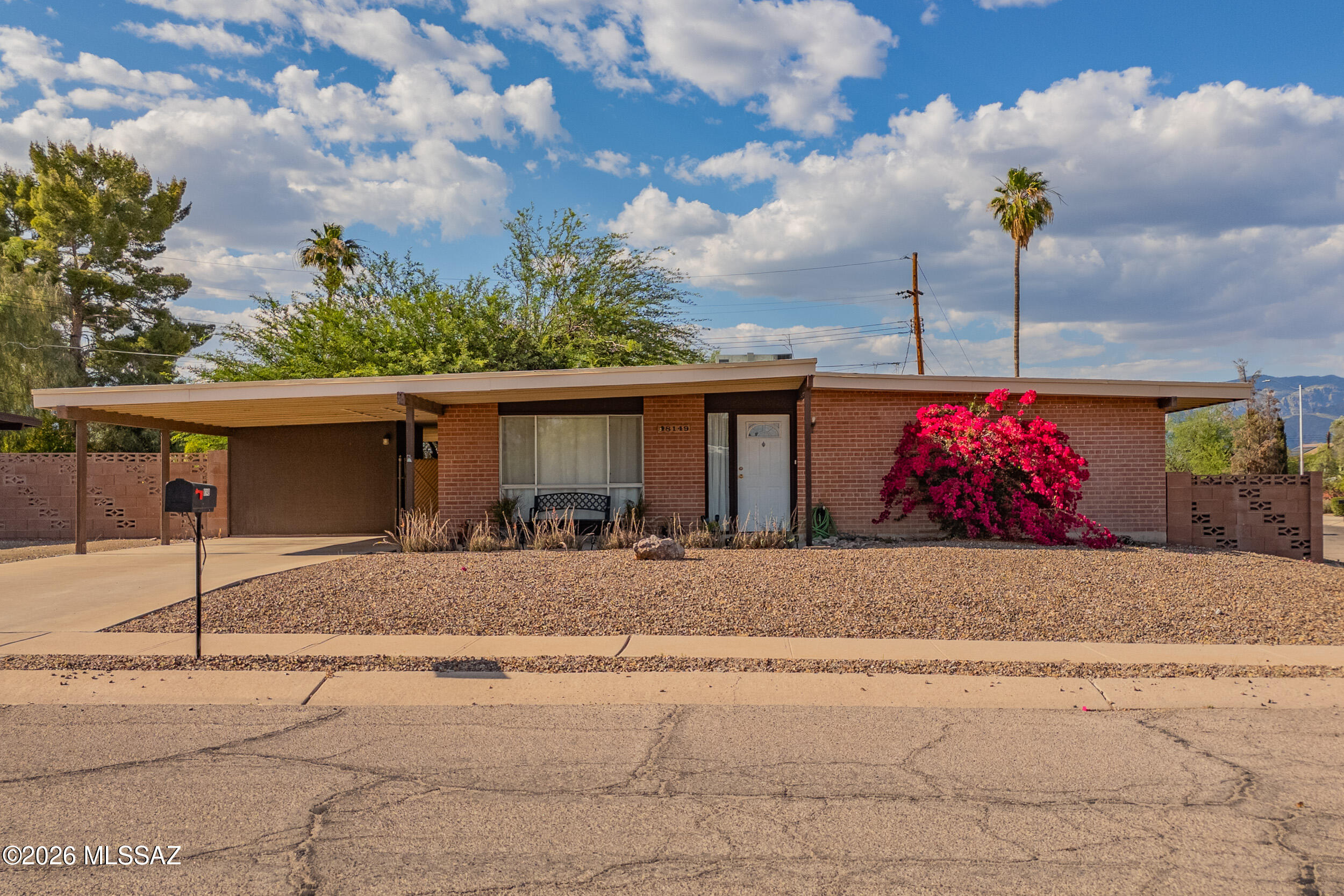 Charming East Side Tucson home on a spacious corner lot with classic Southwestern character and mountain views. This well-maintained single-story brick residence features bright living spaces, large picture windows, neutral finishes, and a comfortable layout designed for everyday living. The expansive living room flows into the dining area and kitchen, while generously sized bedrooms provide flexibility for guests or a home office. Step outside to enjoy the oversized backyard with mature shade trees, decorative block walls, and a covered patio perfect for relaxing or entertaining year-round. Conveniently located near shopping, dining, parks, and everyday amenities, this home offers comfort, privacy, and endless potential in a desirable Tucson neighborhood.