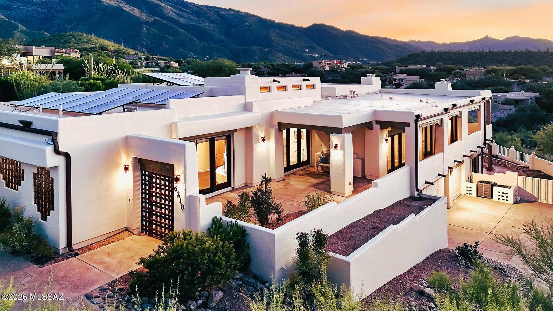 Beautiful Alta Vista home! This owned-solar, 4,465 sq. ft., two-level Santa Fe Modern residence has been thoughtfully updated and revitalized. Perched on a hilltop, the property captures sweeping views of the Santa Catalina and Rincon Mountains, along with spectacular Tucson Valley and city lights.
The main level features newer porcelain tile and scraped engineered wood flooring, an inviting entry living room, and a convenient powder room. The primary suite offers a corner fireplace, ensuite bath with double vanities and walk-in shower, generous walk-in closet, and access to a private patio.
The spacious cook's kitchen provides abundant storage, two center islands, and newer stainless-steel appliances, including a 6-burner, double-oven range. An eat-in nook complements the separate formal dining room. The kitchen opens to the family room, highlighted by 12' ceilings, viga beams, a wood-burning fireplace, floor-to-ceiling windows, and access to wraparound balconies overlooking the Tucson Valley and city lights.
The second and third bedrooms are generously sized, each with a walk-in closet, and share an updated Jack-and-Jill full bathroom. The lower level provides a separate living area with entertainment bar, corner fireplace, and an additional office or exercise room not included in the square footage. A second primary bedroom offers a full bathroom, fireplace, and direct access to the backyard and garage.

Both the interior and exterior have been freshly painted. Three new 2026 HVAC systems provide updated climate control. The grounds have been revitalized with more than 30 trees, including fruit trees, complemented by covered patio & outdoor kitchen & extensive hardscape. Additional features include rolling security shutters along the south side of the home and an underground 250-gallon water-harvesting tank.

A 3-car garage and abundant off-street parking complete this exceptional .81-acre property.