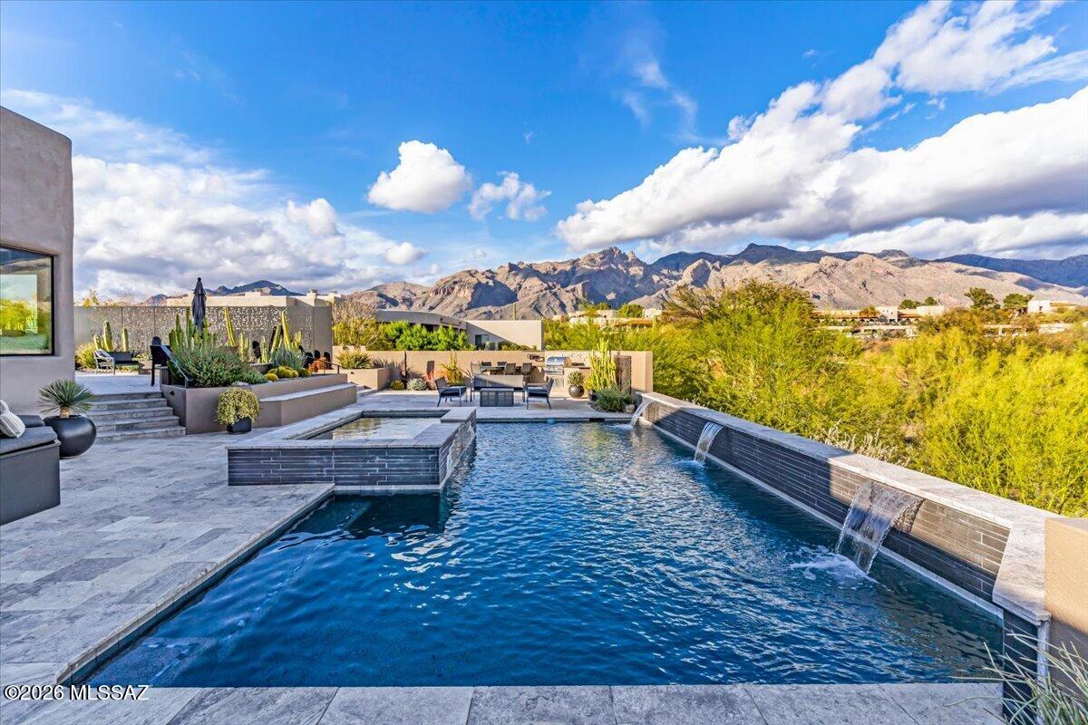 Thoughtfully updated & meticulously maintained Contemporary home in gated La Paloma Estates. Elevated lot showcases spectacular mountain & city views and offers unmatched outdoor living; dramatic infinity -edge pool w/spa and multiple lounging & entertaining areas. The light filled open floor plans offers uplifting views and  includes 4 bedrooms, 2.5 beautiful baths, gorgeous kitchen with excellent layout, storage, counterspace and top-tier appliances. cabinetry and fixtures.