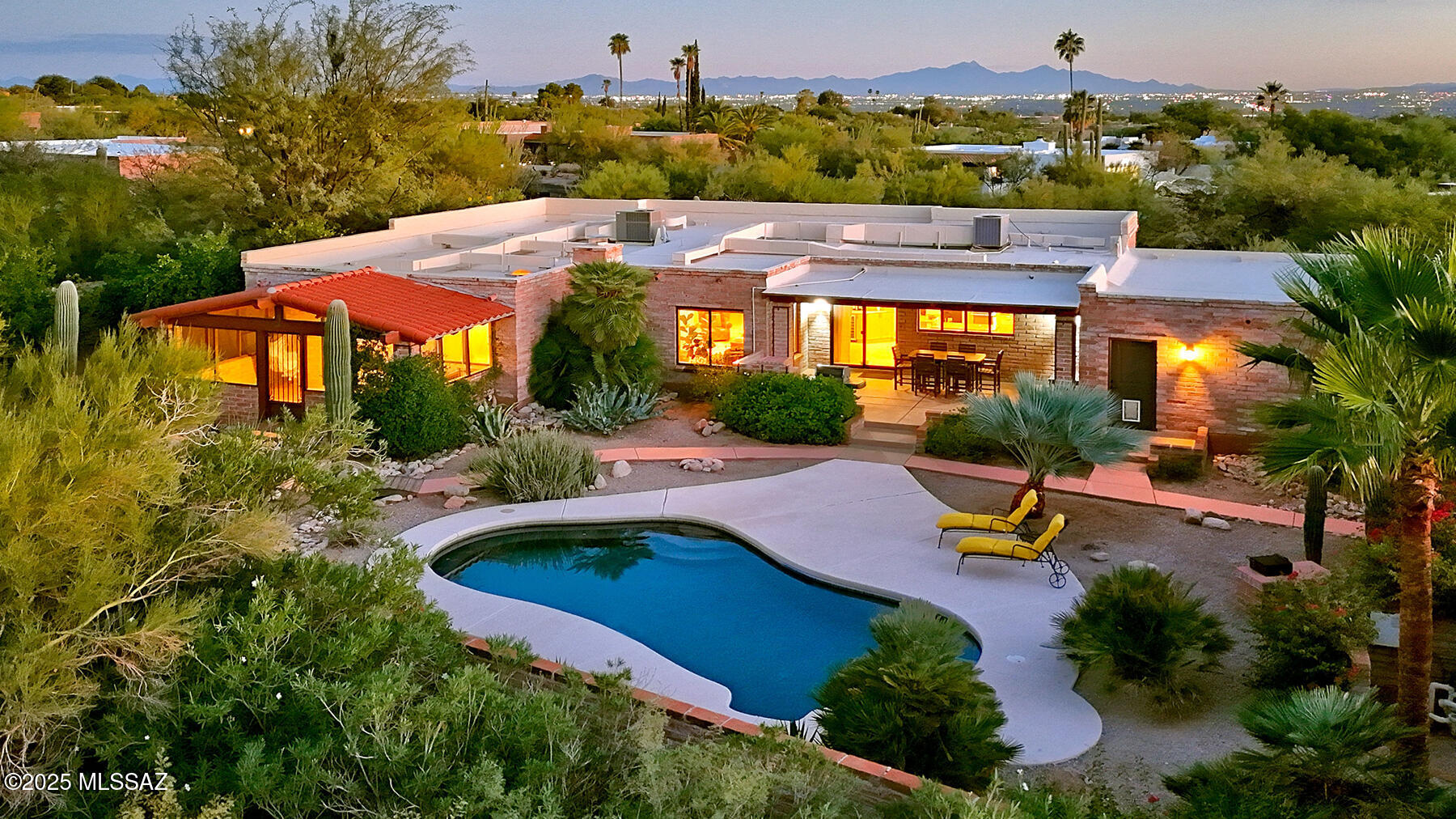 This beautiful 2,748 sq. ft. classic burnt adobe Territorial, nestled on 1.06 acres in highly desirable Catalina Foothills Estates #8, has been tastefully remodeled and updated. Every detail has been re-imagined with style and quality, creating the feel of a brand-new home while preserving its timeless burnt adobe character. The home offers 3 bedrooms, an office/den, an Arizona room, and a 2-car garage with generous storage/workshop area. Expansive front and back porch provide serene outdoor living, complemented by a pool area, lush landscaping, beautifully grounds with walkways, and a large walled-in side yard with a basketball half-court.  Interior features & upgrades include an open flowing floor plan with raised ceiling and neutral designer tile flooring, a cozy brick fireplace, a living area/dining area/family area combination offering a flexible layout, and an office/den that can easily be converted to a 4th bedroom. The remodeled chef's kitchen provides granite counters, knotty alder cabinetry, stainless steel appliances, a walk-in pantry, and a breakfast bar.  The gracious primary suite offers extensive custom knotty alder built-ins, access to the charming Arizona room, and a stylish bathroom complete with designer stone surrounds in the shower, a modern soaking tub and dual vanities.  The property is conveniently located minutes from La Encantada Mall, close to district 16 schools and Pusch Ridge Academy, and just 12 minutes to the University of Arizona.  This is a Tucson GEM, a rare blend of classic territorial-style and modern luxury, priced to sell!