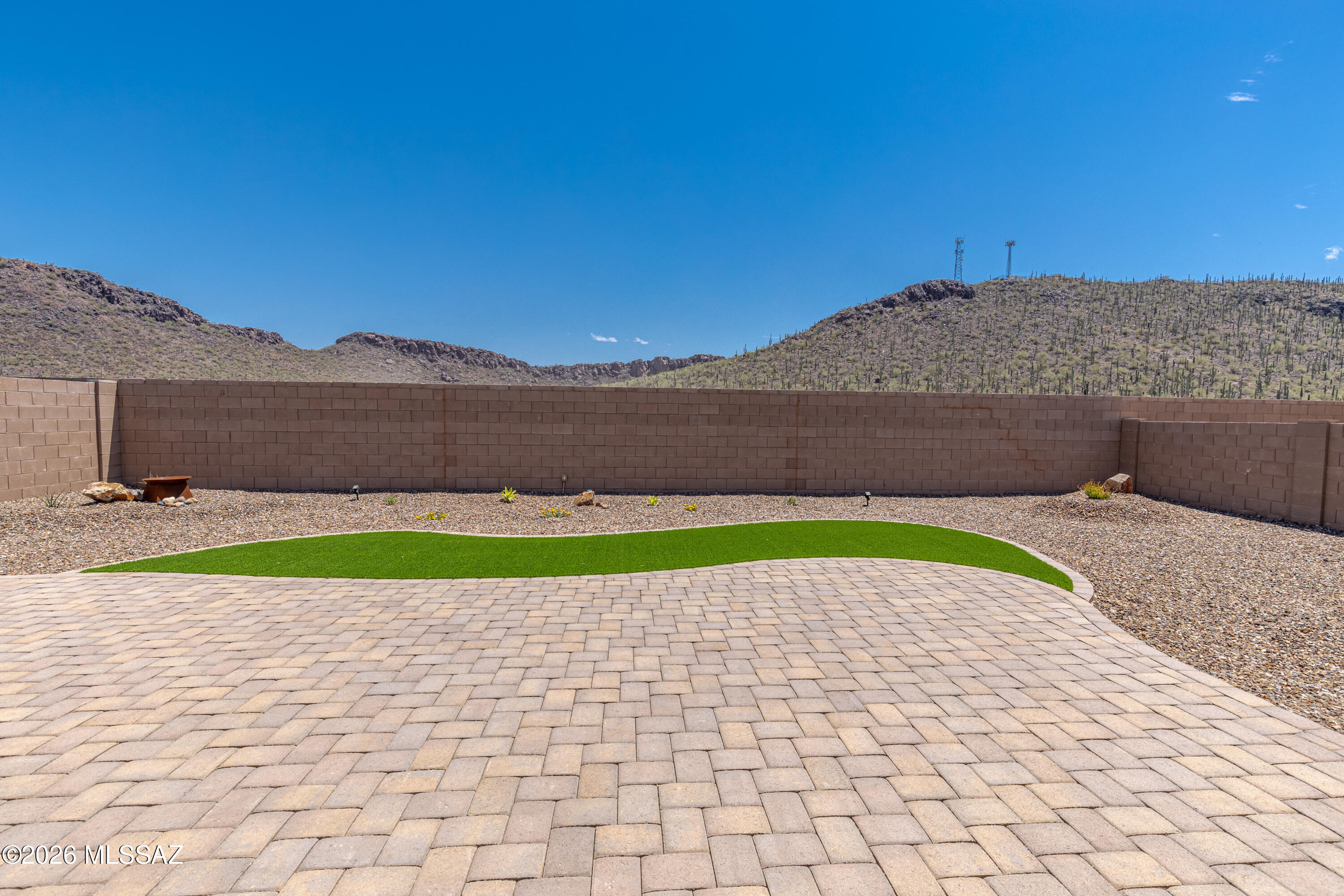 Built in 2023, this exceptional contemporary home in Saguaro Bloom is better than new with its finished backyard, rain gutters, and window coverings. You'll appreciate the premium lot with its picturesque view of the saguaro studded hillside to the east. Featuring an open concept layout, the modern, gourmet kitchen w/center island, quartz countertops, and built-in stainless appliances spills out onto a spacious great room. There are four bedrooms, including a primary suite with a dual sink vanity, a large walk-in shower, & walk-in closet. Enjoy tile floors throughout all of the home except the bedrooms, where plush carpeting makes those spaces inviting. Relish the AZ weather on the rear covered patio with an extended paver patio, some artificial grass, and those pleasant hillside views.