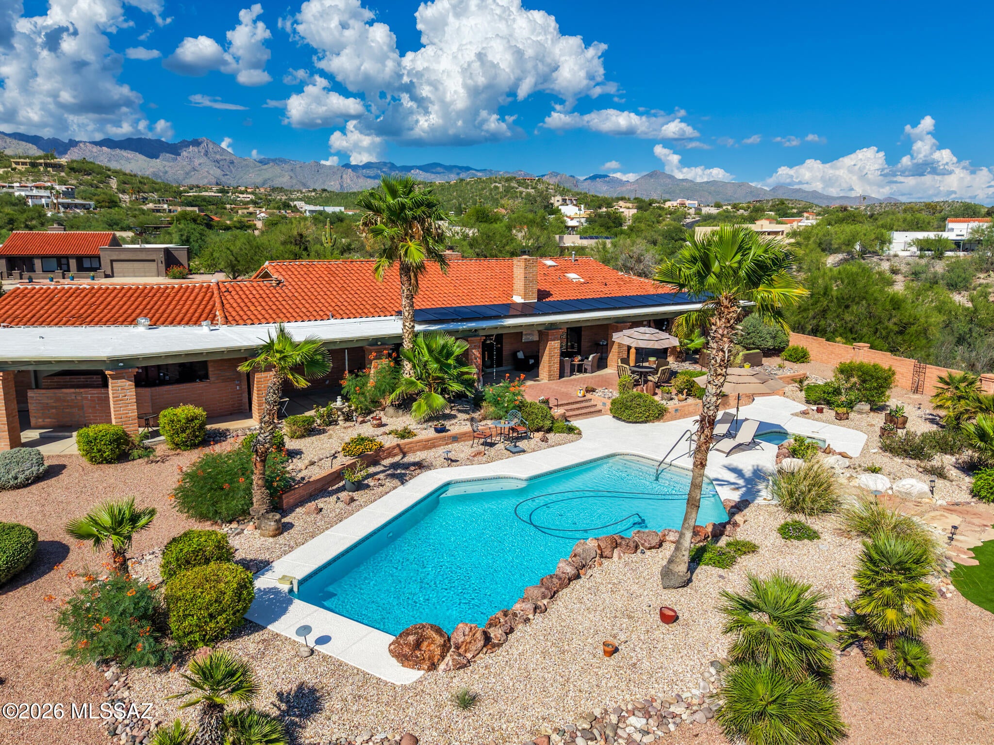 Classic Tucson character meets thoughtful modern updates in this burnt adobe home, tucked at the end of a quiet cul-de-sac in River Hills Estates on eight-tenths of an acre. Backing to a wash, the property offers a sense of privacy along with Catalina and Rincon Mountain views, beautiful sunrises and sunsets, and valley lights after dark.

Inside, 2,986 square feet unfold across a single level with three bedrooms and three full baths, including two primary suites. Light, neutral interiors create a fresh, modern backdrop for the home's original Southwestern character, with brick floors, warm wood, Talavera tile and copper accents adding texture and personality. Soaring and vaulted ceilings and abundant natural light make the living spaces feel open and inviting. replaced sliding glass doo A formal dining room and sunny breakfast nook provide both everyday and entertaining spaces, with new kitchen and dining windows bringing even more natural light into the home.

The kitchen blends warmth and character with wood and glass-front cabinetry, Talavera tile, a gas cooktop and distinctive copper hood, while new appliances and two pantry closets add everyday function.

The main primary suite has its own new sliding glass door to the backyard and a spacious en-suite bath with soaking tub, newly remodeled shower, two walk-in closets with built-ins, private water closet, double vanity and copper sinks. The second primary suite offers vaulted ceilings, a sitting area and its own en-suite bath with tiled shower and granite-topped vanity. A third full bath serves the remaining bedroom and provides convenient access to the backyard.

Recent improvements extend well beyond the finishes. From 2023-2026, both furnaces and both A/C systems were replaced. The flat roof was recently recoated, with approximately ten years remaining on the roof warranty and three years remaining on the A/C warranty. The home also features solar.

Outside, a deep covered patio stretches along the back of the home and overlooks a resurfaced pool and spa, artificial turf, refreshed rock and mature landscaping that attracts butterflies and abundant birdlife. Start the day with sunrise over the Rincon Mountains, catch the sunset from the pool and spa, enjoy Catalina Mountain views from the north-facing courtyard, and watch the valley lights appear after dark.

A rear double gate provides additional access with room for an RV and potential covered parking. With only three homes on the street, the property feels tucked away while remaining convenient to Sabino Canyon, Whole Foods, Udall Park, shopping, dining, hiking, golf and bike paths. No HOA.

Classic Tucson character, modern comfort, room to breathe and a setting made for enjoying the desert from sunrise to sunset.

Electric vehicle charger available to convey with the property at buyer's request; otherwise, seller will remove prior to closing.