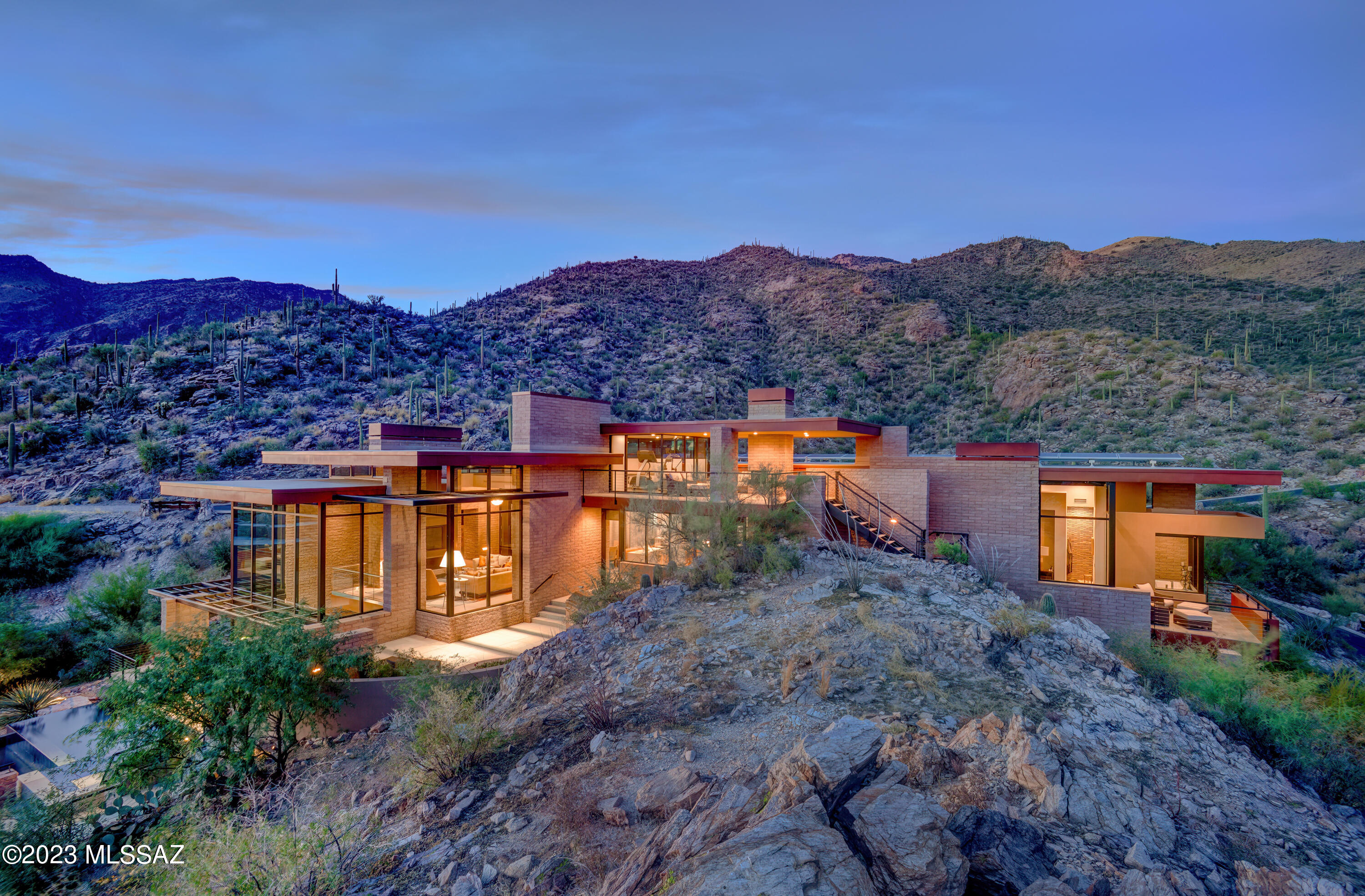 ''Sky Fall''....  Top of the world views, sophisticated & incredible contemporary home on 2.5 acres overlooking city, mountain & sunset views at the top of the prestigious gated community of Ventana Canyon Mountain Estates. Award winning architect, Kevin Howard, designed home to blend with nature by building the home into the fabulous rock formations. The combination of natural stone, rusted steel & commercial grade windows creates the ambiance desired by the owners to enjoy a casual indoor/outdoor Arizona lifestyle with breathtaking views. Exquisite Great Room with high ceilings, dramatic fireplace, floor to ceiling windows, limestone floors, incredible Baulthaup kitchen with light gray anodized aluminum cabinets..... continued..... 2 sub zero refrigerators, Gaggenau 5 Burner Induction Stove Top, 2 Fisher-Paykel Dishwashers, Thermador Warming Drawer & all of  finest appliances, breakfast area, formal dining room, three bedrooms w/ensuite baths + office, family room  w/ extended entertaining lounge area, temp. controlled wine room, 2 powder rooms, laundry room, exercise room, elevator, and solar system in the main house(4889 sq. ft.) plus (382 sq. ft casita w/ 3/4 bath) & 3 car garage. Enjoy the gracious outdoor living w/ 2 spacious patios, BBQ area, gorgeous pool & spa, views, views, views!!!!! *** Lot 43, 6801 Hole in the Wall Way, Tax Code 114-03-117A is also included in the purchase price****** This purchase price also includes (6801 Hole In The Wall Way) Lot 43, Parcel number 114-03-117A
2025 Taxes for the included Lot are $8,411.89