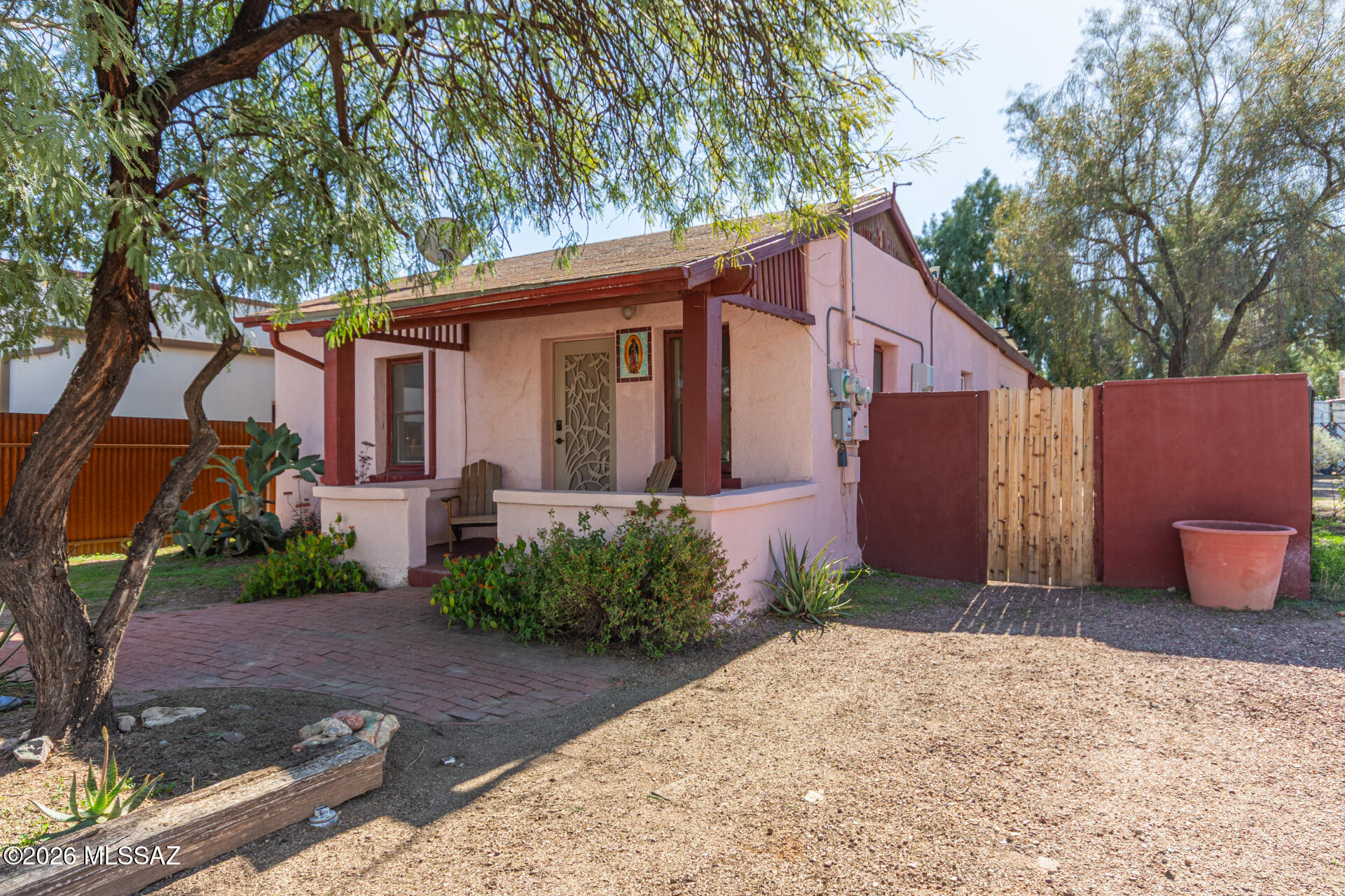 Charming Historic Adobe in Downtown Tucson! Walking Distance to the Mercado District, Old Downtown, and The BIKE LOOP! Be greeted by mature trees & a cozy porch that sets a warm tone from the start. Inside, brick & Mexican tile floors add character throughout. The welcoming living room features a distinctive slump block accent wall, creating a unique focal point, while the spacious dining room is perfect for gatherings & everyday meals! Immaculate kitchen stands out with cheerful green cabinetry, SS appliances, ample counters, & a pass-through window to the dining room. Both bedrooms offer two closets--one w/mirrored closet doors & other w/a built-in bookcase. The bathroom includes a tub/shower combination! An ample laundry room with cabinets adds even more storage.