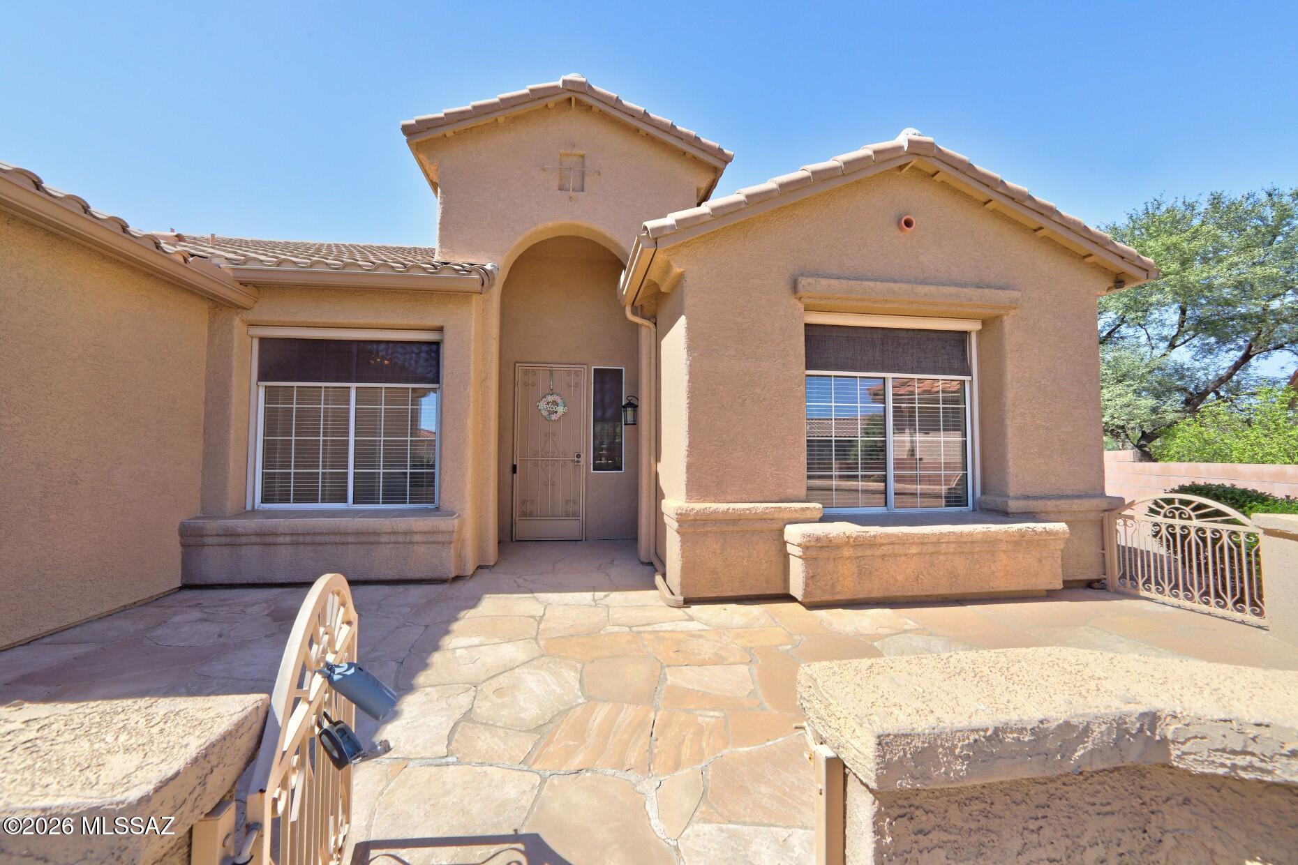 Located in Sunflower at Continental Ranch, a popular 55+ community at the base of the Tucson Mountains and Safford Peak.  This 1,972 sq. ft. Kachina model, built in 2000, offers a desirable floor plan, thoughtful upgrades, and beautiful views of the surrounding saguaro-filled hillsides.
The spacious kitchen features cherry cabinetry, a center island, Corian countertops, pull-out shelving, double ovens, a gas cooktop, and a bay window with room for a kitchen table. Matching cherry built-ins extend into the living room, where a cozy gas fireplace and large windows create a comfortable space to relax and enjoy the desert views.  Power sun shades at all large windows too! The primary suite is privately situated at the back of the home, overlooking the backyard and saguaro-covered hillside. The large window features both a power sunshade and power rolling shutter. Plus a generous walk-in closet with built-ins adds convenience. Garage has nice build in cabinets and the laundry room includes a washer and dryer. The private, gated front and back yard complement the natural desert landscaping. Recent updates include a roof replaced four years ago and a Lennox HVAC/heating system installed five years ago. Enjoy direct garage access to The Loop bike trail, it's an easy ride directly from garage to trail! Activities and amenities; see the Sunflower Communicator for the many activities available to residents of the community.  This home is in an ideal location and the Seller loved this home and it shows!