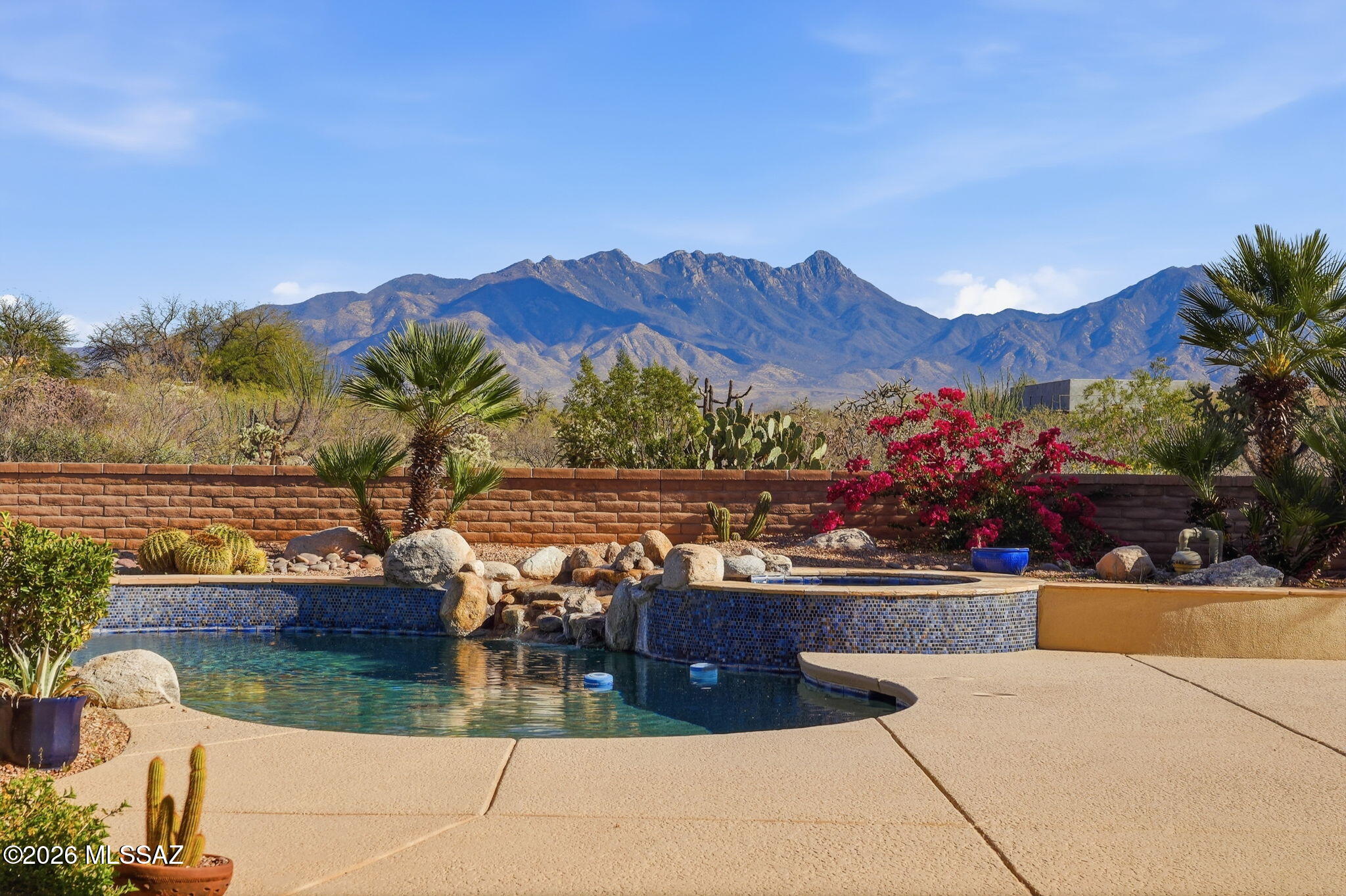Framed by the breathtaking Santa Rita Mountains, this exceptional custom Dorn-built home in Pasadera sits on 4.14 private acres, offering sweeping desert views & refined Arizona living. A charming enclosed front courtyard with a decorative fountain welcomes you, setting the tone for the tranquility found throughout the property. The backyard is designed as a private desert retreat with a gas-heated pool & spa featuring a double waterfall, expansive Kool decking, a built-in BBQ, & a gas fire pit--perfect for entertaining while enjoying spectacular mountain sunsets.  Inside, the home blends comfort & elegance. The gourmet kitchen features granite countertops, abundant custom cabinetry, double ovens, trash compactor, & under cabinet lighting. The adjoining family/game room is an entertainer's dream with a billiards area, media center, and wet bar with wine fridge and mini fridge. A formal dining room with an illuminated tray ceiling adds a touch of sophistication for special gatherings. The split bedroom floor plan offers privacy, with the spacious primary suite capturing mountain views and featuring built-in cabinetry, dual vanities, a jetted soaking tub, custom tiled walk-in shower, and a large walk-in closet with custom organization. A dedicated office/den provides the perfect work-from-home space.

Additional highlights include an expansive laundry room that doubles as a hobby room, a three-bay oversized garage with workshop and storage, and a soft-water hose bib for washing vehicles.

Important upgrades include owned solar for low utility costs, HVAC replaced in 2016 (warranty through Sept 2026), dual-flush toilets, new service utility doors, and fresh exterior paint with updated landscape rock and drip irrigation.

Surrounded by mature desert landscaping and towering saguaros, this remarkable property offers privacy, space, and unforgettable views. GVR membership is not included but can be added if desired.