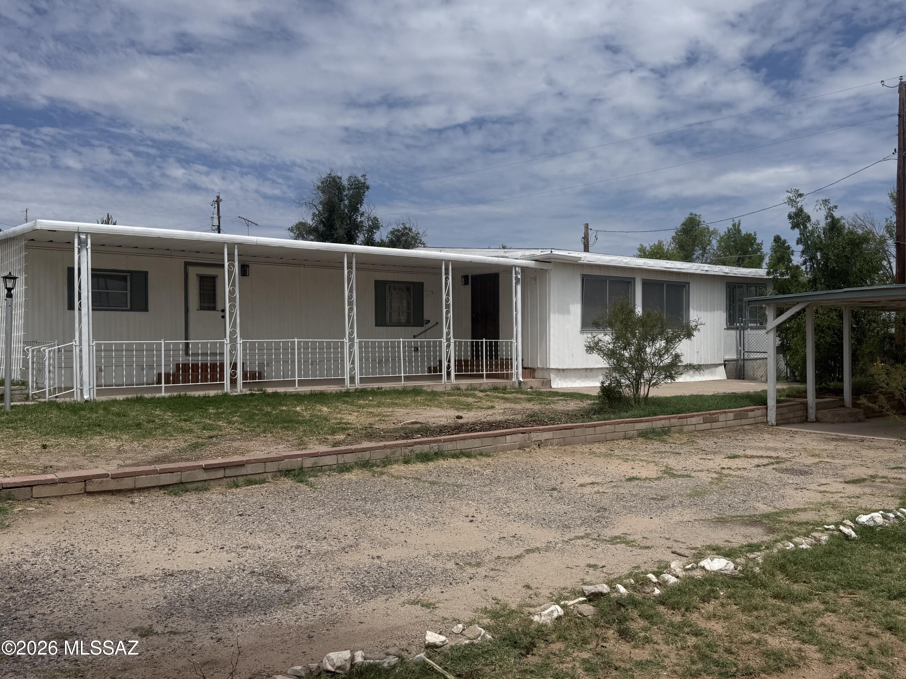This updated Mobile Home on a large city lot features 3 bedrooms and 2 bathrooms. It was recently renovated in 2024 including the wiring, bathrooms, flooring, walk in closet added in the primary bedroom, some window replacement, installation of a gas furnace, hot water heater and membrane replacement on the roof. There is an attached covered patio with a view of the Dragoon Mountains, a detached carport and room for a garden or picnic area under the large backyard tree. Convenient downtown location close to schools, shopping, restaurants and medical facilities.