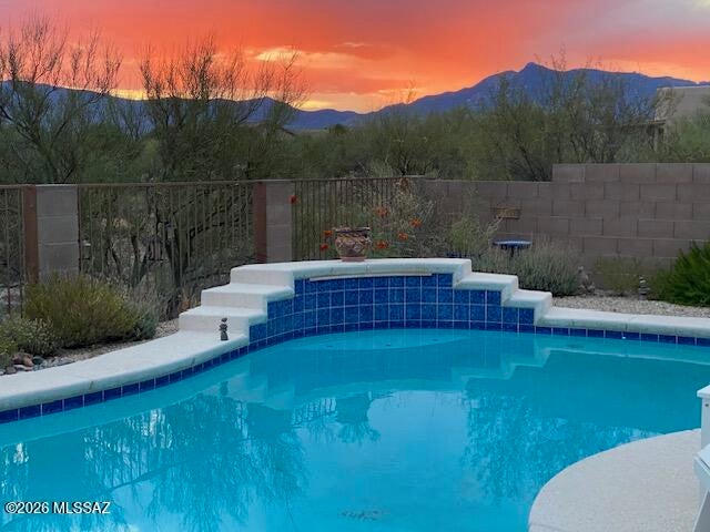 PREMIUM UPGRADES AND MOUNTAIN VIEWS! This beautiful home offers an exceptional combination of comfort, efficiency, privacy & outdoor living on a quiet .47-acre lot with no back neighbors & a non-pass-through street. A NEW ROOF adds valuable peace of mind, while energy-efficient 2x6 construction & double-pane windows enhance year round comfort. Beautiful ceramic tile flooring flows throughout with motorized blinds in the Great Room, ceiling fans, custom security doors & a remodeled hall bathroom. The kitchen features granite countertops, new backsplash, canned lighting, pull-out shelves & abundant counter space & cabinet storage. French doors open to the back patio & an incredible backyard retreat with artificial turf, safety-fenced 10' diving pool with waterfall. A home to love and enjoy!
