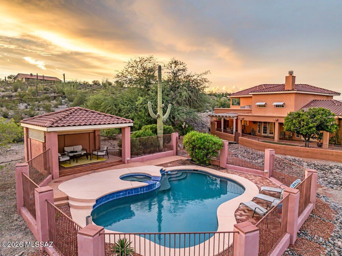 Welcome to a truly one-of-a-kind custom estate nestled on 3.31 acres of horse-zoned Sonoran Desert in Northwest Tucson. Elevated to capture breathtaking Catalina Mountain and city-light views, this exceptional property offers the rare combination of privacy, expansive acreage, resort-style amenities, and convenient access to the city.

Built in 1995, this approximately 3,218-square-foot frame-stucco Southwestern home has been thoughtfully updated with contemporary finishes while maintaining its distinctive desert character. The airy, open-concept interior features abundant natural light, skylights, soaring ceilings and spacious formal living and dining areas designed for both everyday living and entertaining. The split-bedroom floor plan provides excellent privacy, with the spacious primary suite conveniently located on the main level.

The primary retreat features a luxurious soaking tub, walk-in shower, oversized closet, and direct access to the patio. The beautifully updated kitchen offers custom cabinetry, ample storage, granite countertops, black stainless-steel GE appliances, and a large center island that serves as the heart of the home.

Upstairs, a spacious loft provides additional living space along with two bedrooms, a full bathroom, and two private balconies. The west-facing balcony captures spectacular Sonoran Desert sunsets, while the east-facing balcony showcases stunning mountain views and a unique evening display as the Catalina Mountains glow red in the setting sun. Both balconies offer an incredible vantage point for taking in Tucson's spectacular star-filled night skies.

Outdoor living is truly exceptional. The resort-style backyard features a heated pool and spa, enclosed pool and ramada area, extended patios, citrus trees, and expansive views of the surrounding desert landscape. The property is also frequented by an impressive variety of native wildlife, including owls, deer, javelina, bobcats, and more, creating the feeling of your own private nature preserve.

For those seeking space for vehicles, recreational equipment, or an equestrian lifestyle, the property offers a spacious three-car garage with storage, a detached RV carport, and a detached storage shed. The horse-zoned acreage provides room to enjoy the freedom and possibilities that come with owning an expansive desert property.

Located on the west side of Northwest Tucson, the home offers a peaceful desert retreat while remaining conveniently accessible to major shopping destinations and Interstate 10.

This is more than a home--it is a private desert estate offering spectacular views, abundant wildlife, indoor-outdoor living, resort-style amenities, horse-zoned acreage, and a level of privacy that is increasingly difficult to find in Tucson.