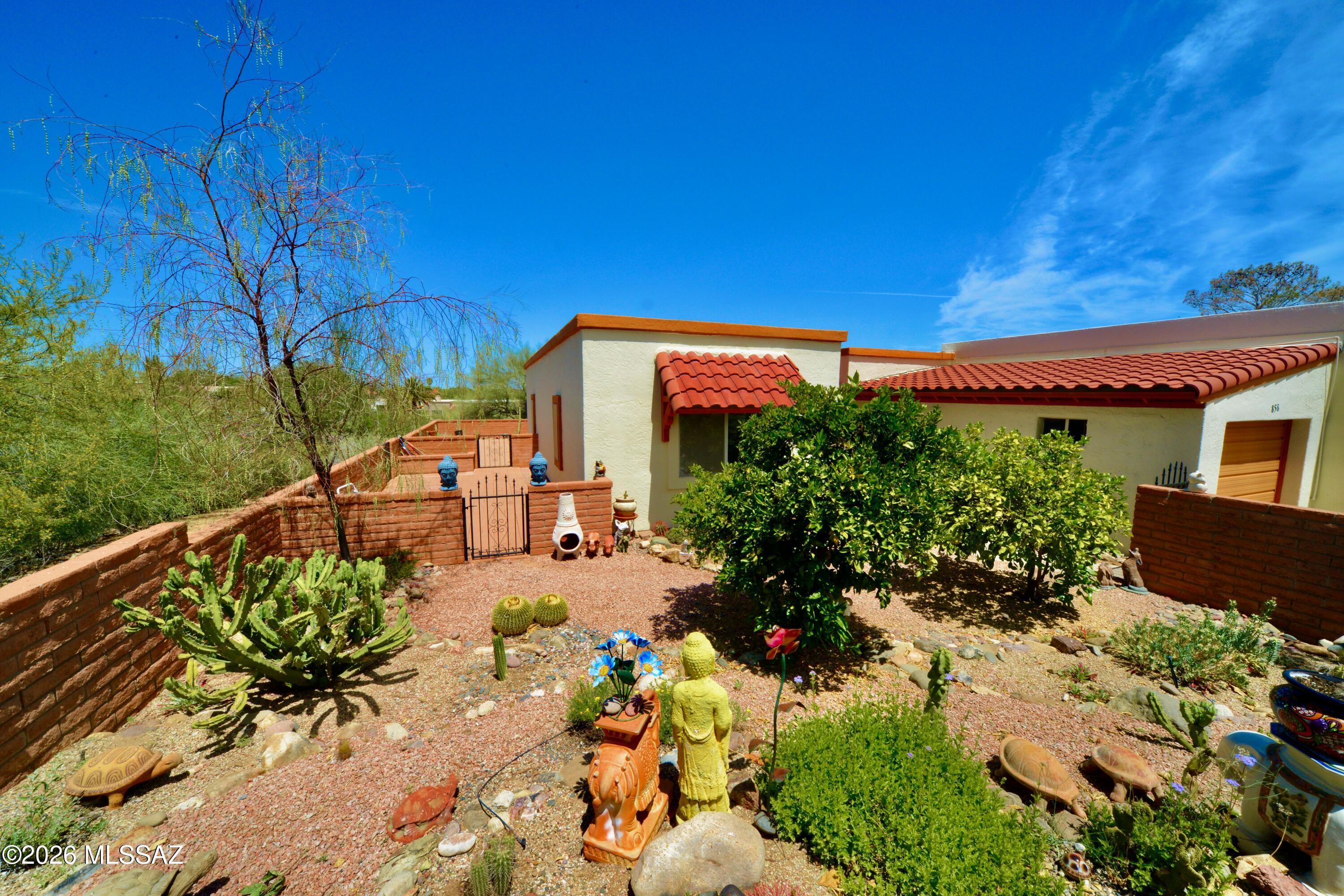 This updated 2 bed, 2 bath townhome blends Southwest charm with modern updates for comfort & style. A lush, welcoming garden sets the tone, creating a peaceful entry & outdoor retreat, while the wraparound patio offers space to relax & take in sweeping desert vistas & mountain views. Elevated positioning backs to wooded desert with open skies, added privacy & no rear neighbors. Inside, tile flooring provides a clean, cohesive feel. The Arizona room opens to the living area, adding approx 252 sq ft of flexible space for a studio or additional living. Roof recoated in 2024 & HVAC replaced in 2022.