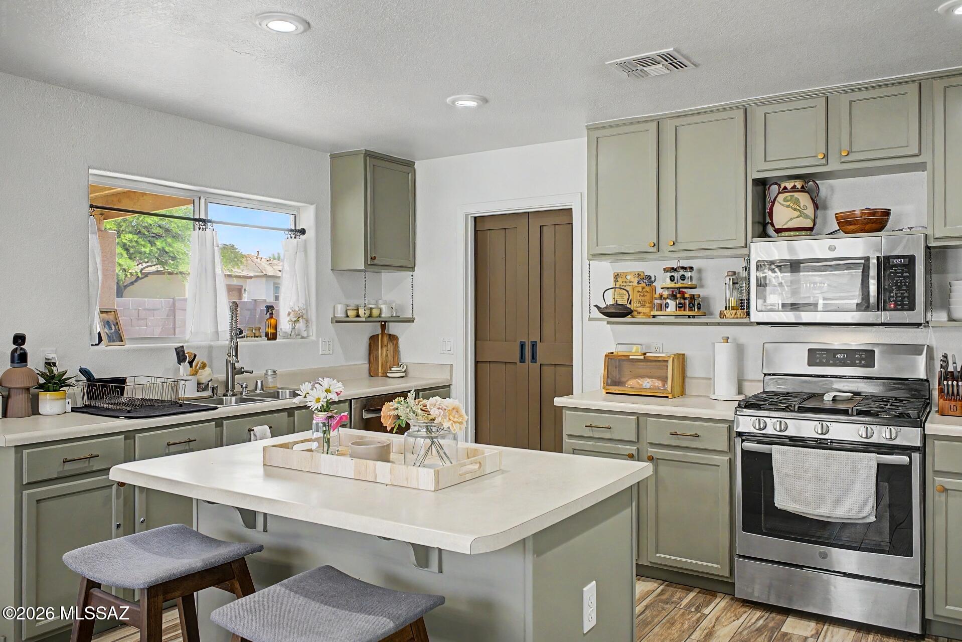 Welcome to a beautifully curated home where warmth, function, and effortless style come together. A soothing natural color palette flows throughout, creating a calm and inviting atmosphere from the moment you step inside.

The heart of the home is the well-appointed kitchen, featuring a spacious center island, perfect for gathering, meal prep, and entertaining with ease. Thoughtfully designed living areas offer flexible spaces to fit your lifestyle, whether you're working from home, hosting guests, or creating a cozy retreat.

The primary suite is a true haven, complete with dual sinks for added convenience and generous under-sink storage to keep everything organized and within reach.

Step outside to your private backyard oasis, where a covered patio invites you to unwind, dine al fresco, or enjoy Arizona's beautiful evenings. The fully fenced yard provides both privacy and peace of mind.

Fresh interior paint adds a crisp, updated feel, making this home truly move-in ready while offering the perfect canvas to make it your own.

This is the one you've been waiting for. Come experience it for yourself.