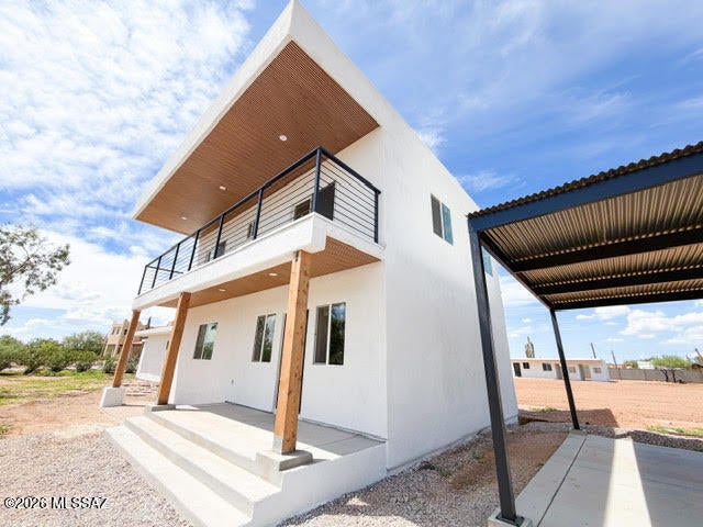 Escape to your own private desert retreat with this newly built custom home offering the space, privacy, and freedom of acreage living--without sacrificing convenience. Nestled on nearly a full acre with no HOA restrictions, this modern two-story home features clean stucco lines, a modern color palette, and gorgeous mountain views right from your own backyard.  This 3-bedroom home is designed for comfort and functionality, with each bedroom boasting its own private en-suite bathroom--perfect for multi-generational living or hosting guests in style. All three bathrooms are finished with elegant tile surrounds and spacious walk-in showers. The open floorplan is filled with natural light thanks to abundant windows throughout, and the upstairs bedrooms share access to a covered private balcony --an ideal spot to unwind and take in the views. An upstairs landing offers a flexible bonus space, perfect for a cozy reading nook or a quiet home office setup. Downstairs, durable ceramic tile flooring flows throughout the main living areas, while plush carpeting upstairs adds warmth and comfort to the bedrooms. Inside, modern touches abound, including sleek black metal stair railings and gorgeous white quartz kitchen countertops that bring a fresh, contemporary feel to the home. Outside, the property truly shines for hobbyists and horse lovers alike. A dedicated workshop/horse stable area and abundant open space give you room for all your toys--RVs, trailers, equipment, or animals. A striking four-rail black fence lines the property front, adding curb appeal while defining generous, usable outdoor space, and corrugated metal fencing along one side adds an extra layer of privacy. A covered front porch welcomes you home, and a detached 2-car carport provides convenient covered parking. Despite the peaceful, wide-open feel, you're just minutes from premier shopping centers, restaurants, grocery, gym, entertainment and easy I-10 access--giving you the best of both worlds: country living with city convenience. Don't miss this rare opportunity to own new construction with acreage, privacy, and modern style all in one place. **ASK ABOUT 1% RATE BUYDOWN ON THIS HOME**