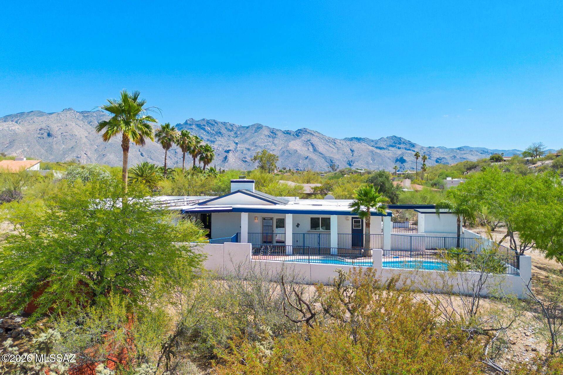 Tucked away on a private lot, 4581 N Avenida Del Cazador offers a highly accessible Catalina Foothills location paired with peace and quiet. Set far back from the road down a dedicated paver driveway, this classic single-story masonry stucco home is completely surrounded by desert open space. This single-story home features 2,234 square feet with no interior steps. 

Inside, you will notice fresh neutral paint, Saltillo tile in the main living areas, soaring ceilings, and a two-way stone fireplace provides a natural separation between the main living spaces.
Outside, the fully fenced backyard is low-care and ready to enjoy, featuring mature palm trees, artificial turf, and a newly plastered tailored for Tucson summers. The attached two-car garage, two additional carports and extra space around the property provides excellent coverage for vehicles.  Don't miss the generous space on the west side of the property offering excellent potential for expanding your outdoor living area or adding other improvements.

Many functional upgrades have recently been made to the home, including a new roof (2023), fresh interior paint, and new carpet in the bedrooms and hallway. Additional improvements include newer HVAC systems (2023/2015), all windows replaced since ownership, new pool tile and plaster (2026), driveway and carport enhancements, and a new Tesla solar system to maximize sustainability (2024).

This location offers incredible convenience to enjoy everything that Tucson has to offer. Access to "The Loop," a 135-mile paved multi-use path is only a mile walk or ride but also includes a parking area. Within a mile there are robust school options, including BASIS North, The Gregory School and Castehill Country Day School. Within that same 1-mile radius you will enjoy access to Whole Foods, Natural Grocers, a pharmacy, bank, fitness facilities and various retail shops. TMC is 8 minutes, Sabino Canyon is 9 minutes, and the University of Arizona is under 20 minutes.