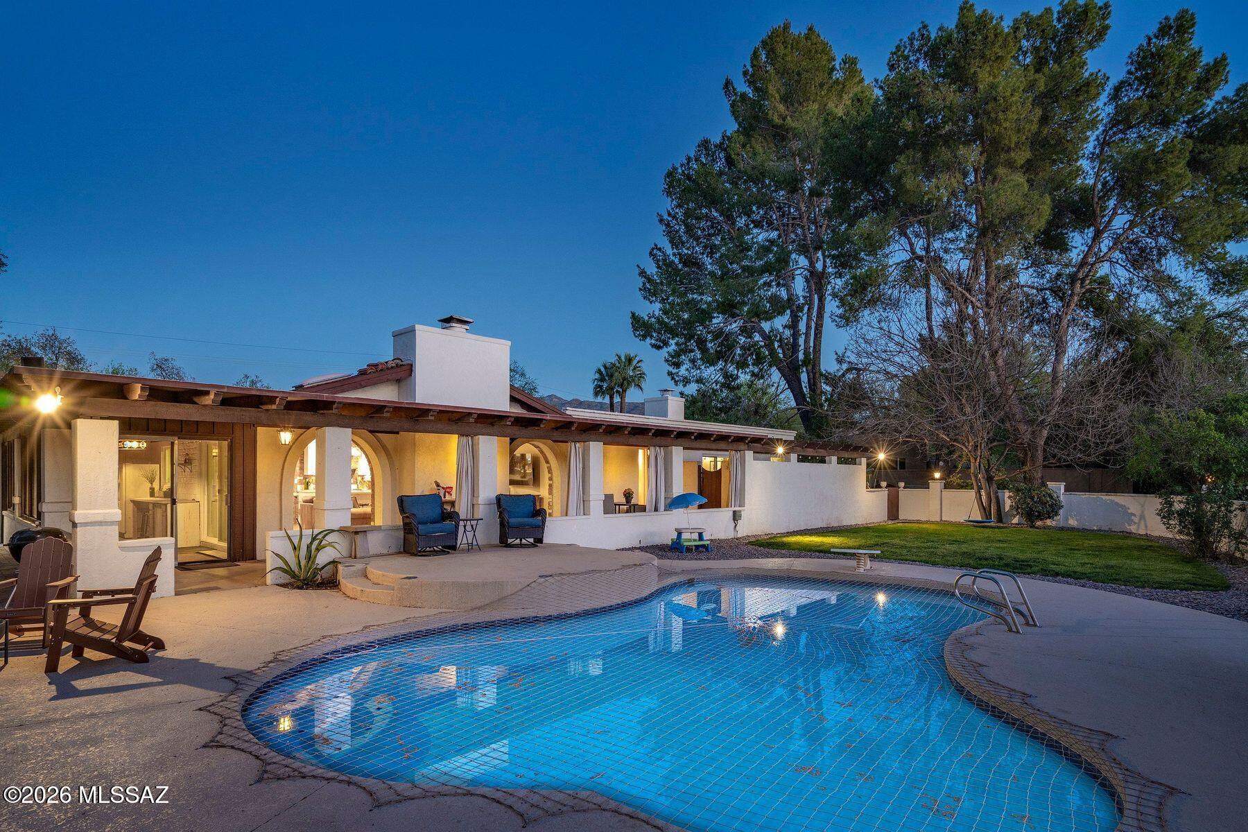 Completely renovated five-bedroom, four-bathroom masonry-built home situated on a private, .65-acre lot in the sought-after 49ers Country Club in the tranquil Tanque Verde Valley. This nearly 4000-square-foot home, set on the 17th hole of the 49ers golf course was thoughtfully redesigned to maintain the charm of the original home while bringing every inch up to date. Set back on the lot, a circular driveway and a red-brick walkway welcome you to this modern ranch-style home that preserves classic character with wood-beam accents, exposed brick, and large arched windows that flood the space with natural light. Spacious entry with rich engineered wood floors, a formal dining area with room for large-scale entertaining, and a spacious living room. The kitchen with a center island and breakfast bar opens to the family room with a brick fireplace and flows into an Arizona room that serves as a flexible entertaining space, refuge from the elements, and additional space for serving food and storing kitchen supplies. Updates and upgrades in the kitchen include quartz and butcher block counters, new cabinetry and hardware, stainless steel appliances including a magnificent GE Monogram gas range with a hood vent, two sinks, wine/beverage refrigerator, and so much more. The split-bedroom floor plan adds to the privacy and livability of this five bedroom plus bonus room home. The versatile bonus room, currently a playroom, can easily serve as an office, den, music room, or media space. The next-level primary suite features a beehive fireplace, a private patio, and a beautifully renovated bathroom with two sinks/vanities, soaking tub with wood-accent feature wall, custom tile shower with glass enclosure, and a spacious walk-in closet with custom built-ins.
 The additional bathrooms have been updated with new fixtures, tile, vanities, mirrors, and custom tiled showers. The backyard offers a resort-style setting with a newly plastered pool equipped with a safety net, a large grassy area, and covered patios that create an inviting outdoor living space. Sunset and golf course views complement this lush homesite lined with mature trees.This home has new Pex water lines, new floors, new windows & blinds, new pool pump, and pool recently re-plastered
Coveted 49ers Country Club amenities include golf, workout facilities, pool, restaurant and bar, holiday events, and outdoor summer movie nights. An active swim team and summer camps create a welcoming community atmosphere. The home is located within the highly rated Tanque Verde School District and is very close to the elementary and middle school. High-demand Hermosa Montessori school is close-by. Private schools such as Desert Christian, St. Michael's, and Castlehill Country Day School are within 20 minutes of the neighborhood. 
Located in the lush Tanque Verde Valley--often called the Green Jewel of the Desert--this exceptional property enjoys a setting unlike anywhere else in Tucson. Traversed by two seasonal creeks, the valley offers an uncommon green desert environment shaded by mature trees and unparalleled natural beauty. Home to approximately 15,000 residents, Tanque Verde is defined by larger parcel properties, open space, and direct access to both the Catalina and Rincon Mountains. Situated at the base of Mt. Lemmon, residents enjoy the rare ability to ski or play in the snow during winter months and escape Tucson's summer heat in the cool mountain air. The result is a relaxed, scenic lifestyle in one of the most beautiful and distinctive settings in the Sonoran Desert.