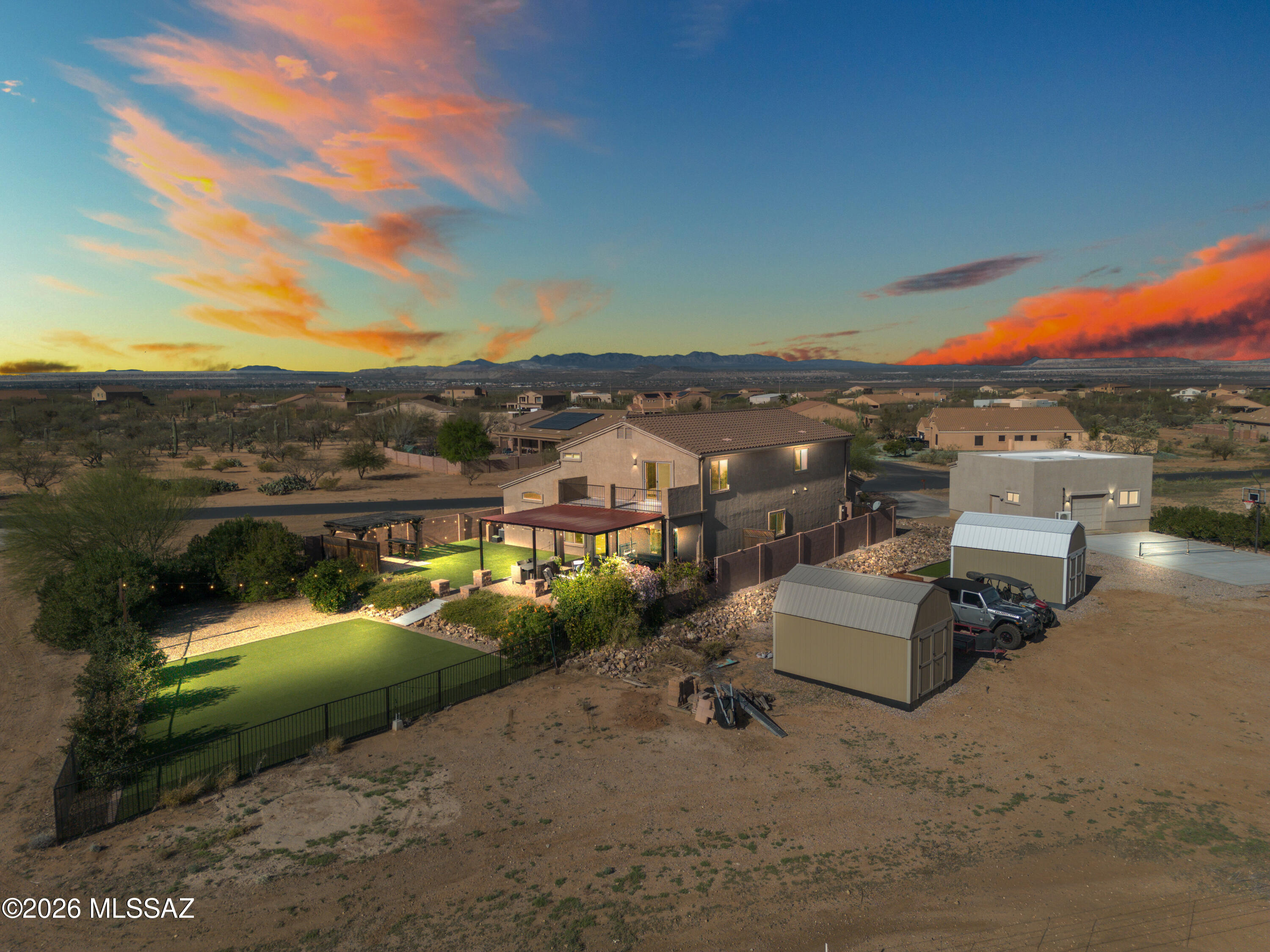 Tucked away in the highly sought-after Sahuarita Highlands, this property is built for those who need room to live, play, and store it all. Situated on an oversized lot with sweeping mountain views, this spacious 3,185 sq. ft. home offers 5 bedrooms, 3 full bathrooms, and the ultimate setup for outdoor enthusiasts, hobbyists, RV owners, or anyone needing serious workspace and storage.
Featuring a 900 sq. ft. detached pull-through garage/shop and your very own pickle ball/basketball court. Combined with the attached 3-car garage, RV parking area, two storage sheds, this property offers flexibility rarely found in today's market. Inside, soaring two-story ceilings create a bright and open feel. The flexible front living and dining area can easily become a game room, media space, playroom, or additional lounge area. The kitchen features granite countertops, rich wood cabinetry, a spacious island, and mountain views right from the sink, all opening seamlessly to the great room for easy entertaining.
The main level also includes a full bedroom and bathroom, ideal for guests, multi-generational living, or a private office setup. Upstairs, the oversized primary suite features double-door entry and a private balcony showcasing breathtaking panoramic mountain views, the perfect place to enjoy Arizona sunsets.
Step outside to a backyard designed for enjoying Arizona living with a large 22' x 22' covered patio, low-maintenance turf, endless open skies, and incredible mountain views. Whether you need room for adventure gear, a serious workshop, or simply extra breathing room, this Sahuarita Highlands property delivers the lifestyle and storage space you've been searching for.