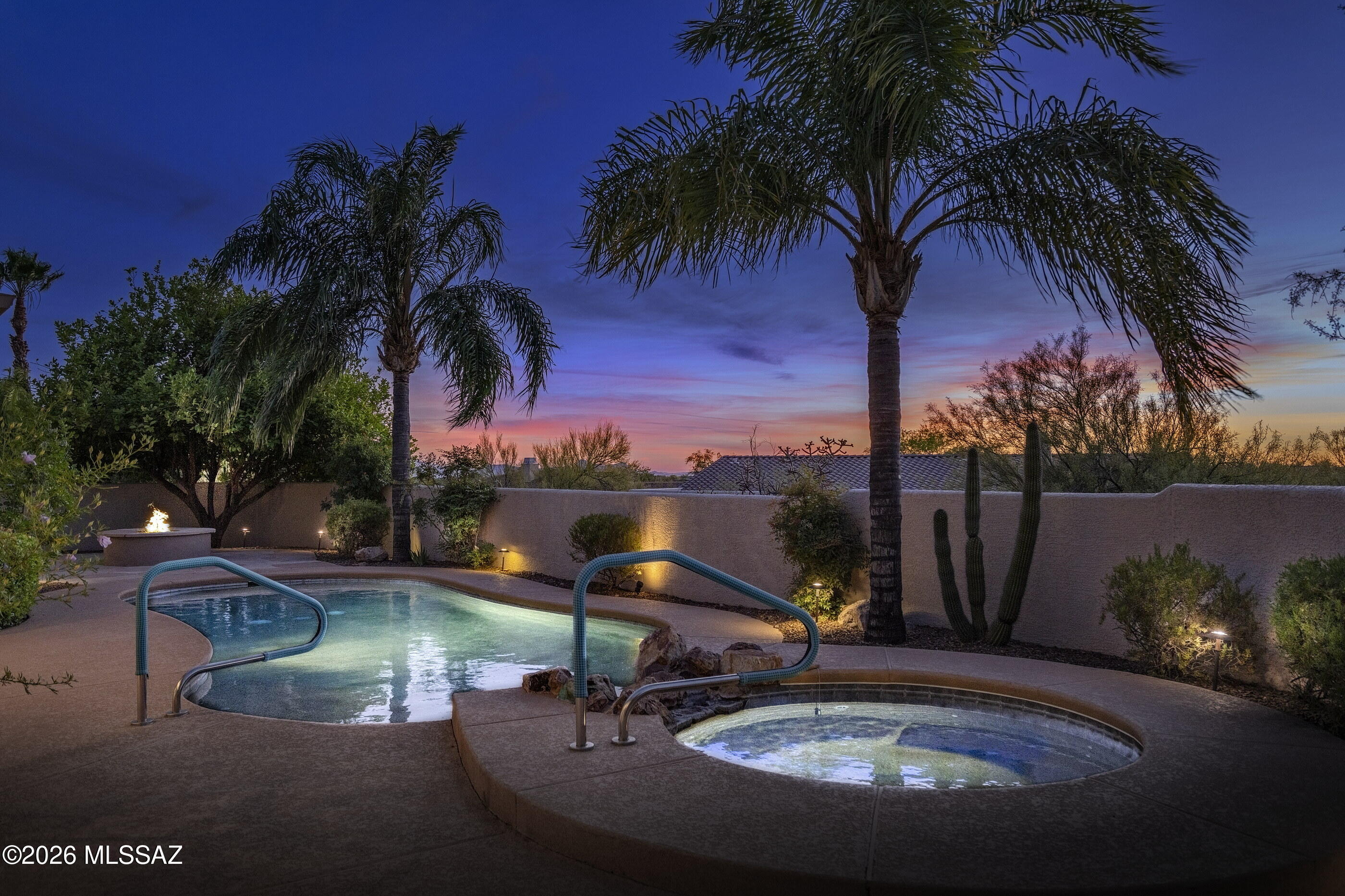 This wonderful 4 bedroom, 3 bath with 3 garage spaces and a pool is ready for new owners! From the moment you arrive, you will notice all the fine details that make this semi-custom Oro Valley home a standout. The long, welcoming driveway sets the stage for effortless entertaining with easy parking and the lush desert landscaping offers stunning mature shade trees.  An arched metal door leads you into a charming, walled in courtyard with brick pavers.  Inside, the 2680 square foot floorplan is a masterclass in flexibility, offering a sense of flow that adapts perfectly to your personal lifestyle. Whether you are hosting a formal holiday dinner under the elegant coffered ceiling of the dining room or enjoying a quiet evening by the fireplace in the casual living area, the home manages to feel both grand and incredibly comfortable. The heart of the home is undoubtedly the kitchen, which balances high-end style with practicality. Featuring quartz countertops, all appliances including a gas range, stylish glass tile backsplash and a large island with bar seating, the kitchen also has space for a casual dining set. You will appreciate the abundance of cabinetry, all thoughtfully equipped with wood pull-outs--including the oversized pantry--to ensure every kitchen tool has its place. The kitchen opens directly to a bright living area that overlooks the backyard, while a second, separate living room provides even more space to spread out and relax. Privacy is a priority here, thanks to a split-bedroom layout that creates distinct wings. The primary suite overlooks the pool and features a separate sitting area that could easily become your favorite yoga spot, a quiet reading nook, or a dedicated space for morning journaling. The attached spa-like bath offers a deep soaking tub, walk-in shower, dual sinks, separate toilet room and expansive walk-in closet. The guest accommodations are equally impressive; two bedrooms share a well-appointed hall bath with a walk-in shower and granite topped vanity, while a third guest bedroom is situated near its own full bath. This clever configuration even offers the potential to enclose a hallway and create a second primary suite if your needs evolve. Practicality is woven into every corner, from the dedicated laundry room with its own sink and storage to the versatile garage spaces. In addition to the two-car garage complete with storage cabinets and its own side-yard access, there is a separate one-car garage filled with natural light, a workbench, and extra storage. It's the perfect footprint for a seasonal workshop or a home gym, with the potential to be a full-time space with the simple addition of a mini-split. The experience culminates in the backyard, a private oasis designed for the quintessential Arizona lifestyle complete with a peek at the Tortolita Mountain range. You can spend your summer afternoons lounging by the pool, your evenings enjoying painted sky sunsets, and winter days harvesting fruit from your mature citrus tree. The large, covered patio features rolling shades, allowing you to control the light and temperature at any hour, while the built-in barbecue and firepit patio invite you to stay outside long after the sun goes down. With a freshly painted interior and easy-care tile through all the main living areas, this home is ready to move in and enjoy.  Rancho Vistoso, located in beautiful and sought-after Oro Valley, is what some call the "gold standard" for a master planned community. With 11 well-equipped parks within its envelope, an abundance of trails for walking and biking and lush Sonoran desertscapes, this community offers something for every lifestyle. Thoughtfully arranged and comprised of over 70+ residential neighborhoods ranging from condos to multi-million dollar estates, Rancho Vistoso also hosts the popular age-restricted community Sun City Vistoso, commercial space and the renowned Innovation Park campus. This gorgeous development also features stunning mountain views in its boundaries and joined access to Catalina State Park (the second most visited State Park in Arizona). Residents also enjoy convenient access to dining, shopping, culture, world-class golf and hiking, a top-notch hospital and more.