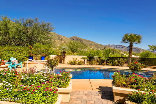 Welcome to The Crown Jewels Estate, where panoramic views sweep across the Catalina Foothills and the glittering city lights sparkle below like a necklace of diamonds. This five bedroom, four bath estate is more than a home. It is a masterfully reimagined sanctuary that balances elegance, modern convenience, and timeless Tucson charm.

Step inside to find every thoughtful upgrade already in place. From the brand new resealed roof to custom iron security doors, solar shades with remote control, and a tankless Rinnai water system with a circulating pump, no detail has been overlooked. The kitchen is a true showpiece, completely redesigned with a relocated cooktop for functionality, a Viking range and microwave, dual Bosch dishwashers, beverage refrigerator, and striking quartz counters. Every appliance, fixture, and cabinet has been carefully chosen, soft close, and perfectly styled.
Every room has been touched with luxury including travertine floors, new high-end carpet in bedrooms, California Closet systems, Hunter Douglas window coverings with remote controls, and custom shower and window installations. Even the garage received the royal treatment with epoxy floors, split air, and California Closet storage.
The backyard is nothing short of a resort. Completely remodeled, it features a Hydrawise app-controlled irrigation system, custom paver patios, a Hestan outdoor kitchen, massive gas fireplace, weatherproof television, and top of the line outdoor speakers. This space was built for entertaining whether you are hosting a lively evening under the stars or enjoying a quiet sunset with the mountains as your backdrop.
Located in the heart of the foothills, this estate offers proximity to shopping, dining, golf, and the best of Tucson living while perched high above it with views so spectacular they inspired its name. When the sun sets and the city lights shimmer, you will understand why this home is truly The Crown Jewels Estate.