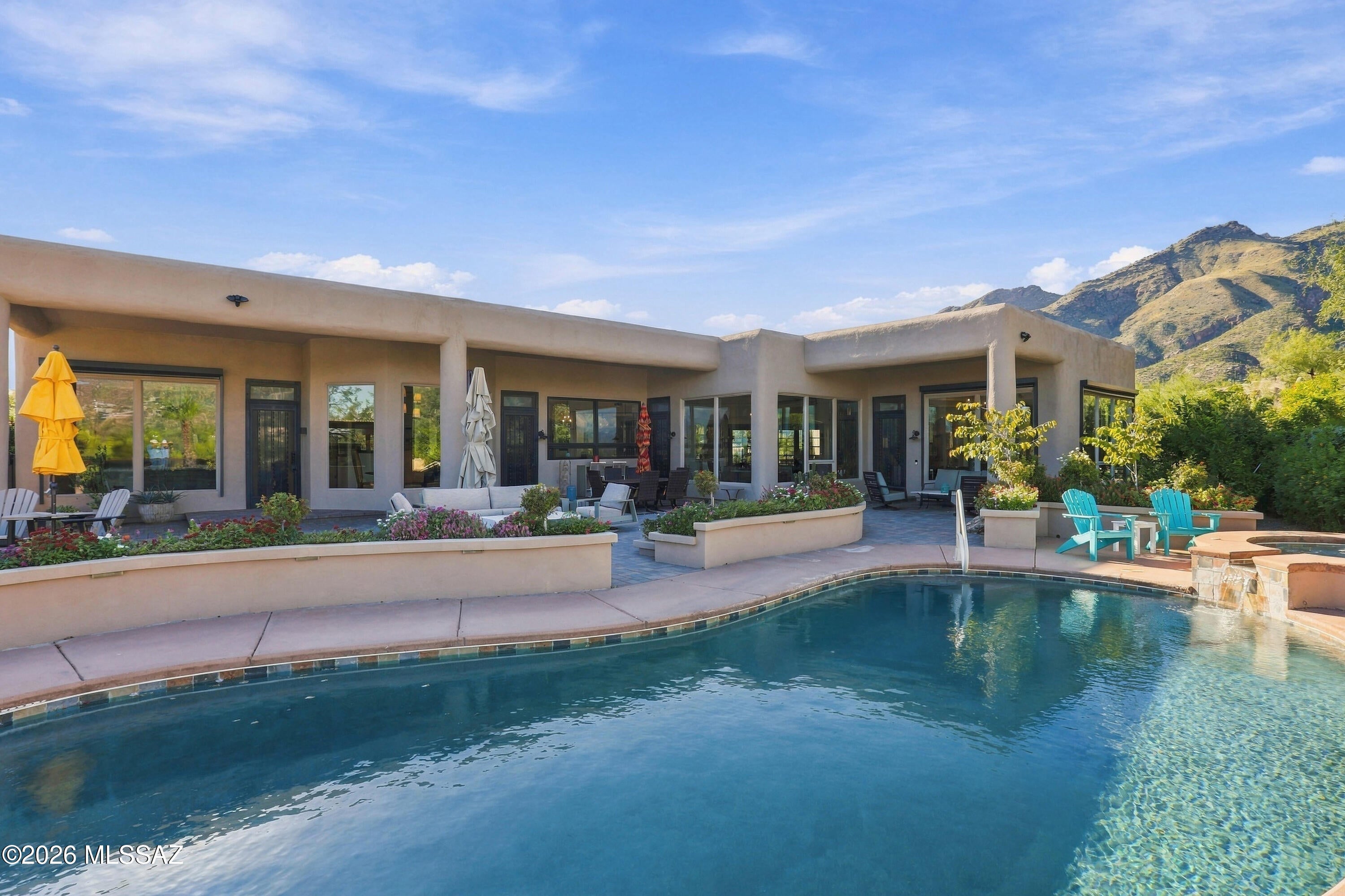 Welcome to The Crown Jewels Estate in Alta Vista, where the beauty of Tucson becomes part of everyday life. This thoughtfully reimagined five bedroom, four bathroom home captures views from every window, with the Catalina Mountains rising so dramatically behind the property they feel close enough to touch. No rear neighbors interrupt the backdrop. As evening falls, the panorama transforms into a glittering tapestry of city lights stretching across the valley below.

For those discovering Tucson, this Catalina Foothills location offers an exceptional introduction. Explore the desert trails of nearby Sabino Canyon, shop at La Encantada, and enjoy a wide selection of restaurants, from casual local favorites to fine dining. Nearby Ventana Canyon offers membership opportunities for golf, dining, recreation, and spa amenities, adding another dimension to the foothills lifestyle.

Inside, extensive upgrades bring comfort and quality to every room. The redesigned kitchen features quartz counters, soft close cabinetry, Viking cooking appliances, dual Bosch dishwashers, and a beverage refrigerator. Travertine flooring, new bedroom carpeting, California Closets, and remote controlled Hunter Douglas window coverings complement the beautifully updated interiors. Practical improvements include a recently resealed roof, custom iron security doors, remote controlled solar shades, and a Rinnai tankless water heater with a circulating pump. The garage features epoxy flooring, a mini split system, and California Closet storage.

The remodeled backyard invites you to settle into Arizona living. A private pool and spa offer the perfect place to unwind while taking in the spectacular scenery. Paver patios, a Hestan outdoor kitchen, a substantial gas fireplace, weatherproof television, outdoor speakers, and app controlled irrigation create an effortless setting for entertaining. Gather with friends beneath the stars or enjoy a quiet evening watching the mountains fade into silhouette and the city begin to sparkle.

Whether you are relocating to Tucson or seeking a desert retreat, this estate brings together mountain views, privacy, thoughtful upgrades, and the experiences that make the Catalina Foothills such a special place to call home.