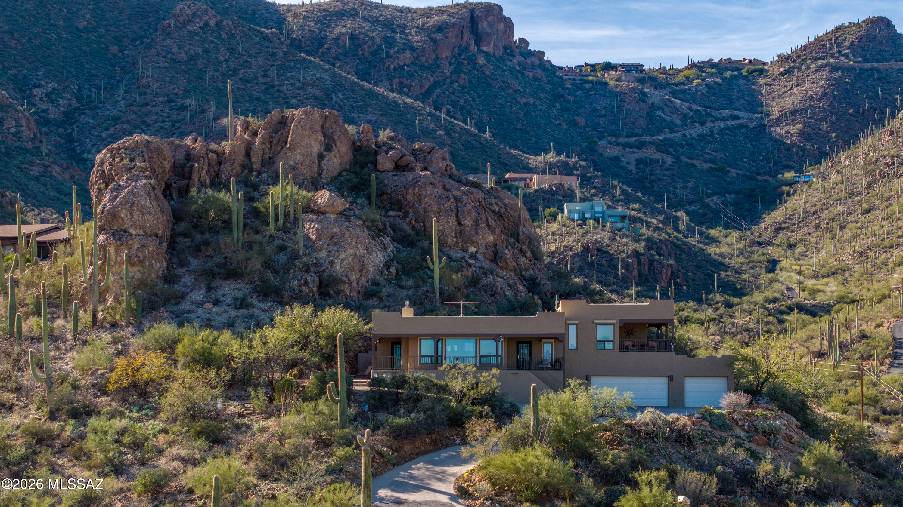 Perched high in coveted Trails End Estates, this exceptional hillside desert retreat captures sweeping city lights & Mountain vistas from nearly every angle. Thoughtfully designed to embrace its dramatic setting, this 3bed/2bath home has a versatile plan w/flexible use options. One bedroom is a 2-room suite that can be  used as office, teen or in-law suite w/exterior access. A popular open living concept plan filled w/natural light. Pella wood  windows perfectly frame panoramic  views. CorTec sound  cushioned floor, exposed wood beam ceilings & wood floors add distinctive appeal.  Gourmet kitchen w/custom Amish cabinets, Sub Zero Frig, Wolf & Thermador appliances. Bar-top island w/stainless & wood accents & wine frig.
The primary suite is a true sanctuary opening to a covered outdoor living wrap around porch perfect for sunrise coffee, sunset cocktails & enjoying Tucson's iconic mountains, valley & twinkling lights.
The new primary bath retreat offers a custom walk-in shower, luxurious soaking tub & spacious walk-in closet w/Cal. closet design for optimal organization.
A spacious three-car garage offers ample storage along w/a separate workshop w/rear pad work area.  This home combines modern living, flexible living spaces, & an elite location surrounded by boulders and blooming desert flora. An energy efficient home w/solar and a car charging station. Tucson rolling shutters  add energy efficiency, light control and security. See the added features list in the documents section of the listing. 
 Homes in this community are rarely offered, don't miss your chance to have top of Tucson Views!