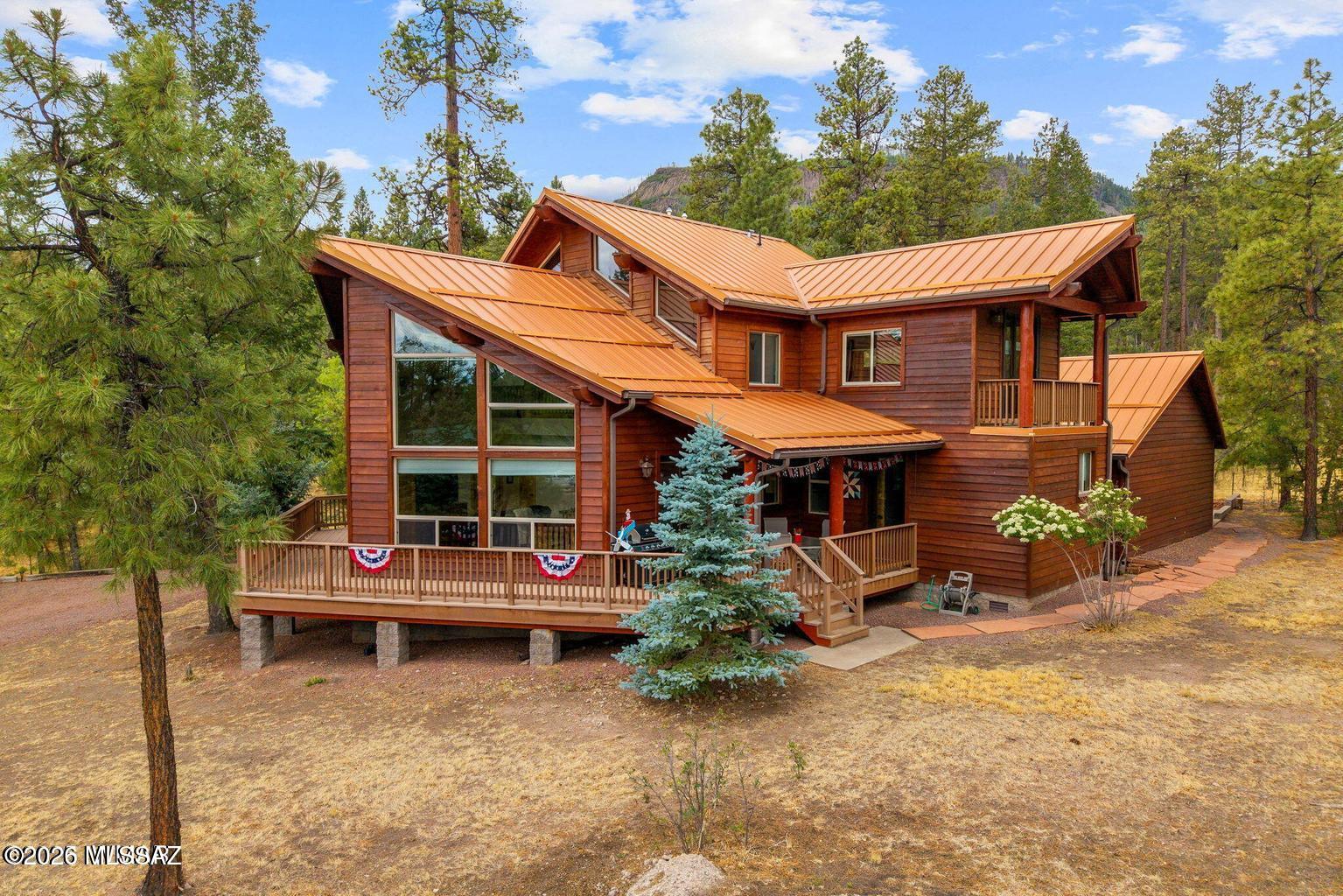 Turnkey Forest Estate | Backs National Forest | Alpine Forest Estates Now Offered at a Newly Adjusted Price Welcome to an exceptional fully furnished custom estate nestled at the base of South Mountain in coveted Alpine Forest Estates. Backing directly to the pristine Apache-Sitgreaves National Forest, this rare offering delivers unmatched privacy, protected views, and immediate access to hiking, wildlife, and year-round recreation. Now available at a thoughtfully adjusted price, this remarkable property presents an extraordinary opportunity to secure a premier Alpine retreat with enhanced value. Spanning 2,353 square feet, the thoughtfully designed multi-generational floor plan offers 4 bedrooms, 3 full bathrooms, and multiple living areas ideal for extended family, holiday gatherings, and entertaining.
The main level showcases a serene primary suite with spa-style bath, an additional guest bedroom and full bath, and a dramatic great room featuring floor-to-ceiling windows, knotty alder cabinetry, granite countertops, custom tile work, and a warm gas fireplace.
Upstairs, two oversized bedrooms (one large enough to serve as a game room), a loft, dedicated office space, and private balconies with French doors invite you to enjoy crisp mountain mornings and cool alpine evenings.
Outdoor living is equally impressive with a 1.5-Trex wraparound covered deck designed for peaceful mornings, summer barbecues, and wildlife viewing.
Exceptional infrastructure and upgrades include:
" Fully finished 3-car detached garage with cabinetry, workbench & Rinnai heater
" Covered breezeway connection
" Generac automatic-start generator
" 1,000-gallon in-ground propane tank
" Rinnai tankless water heater
" Amana dual-zone A/C
" ADA-friendly wide hallways and doors
" Game-ready backyard with concrete recreation pad & gas BBQ stub
" Mudroom with Kohler sink; washer & dryer included
This home is truly turnkey!! just bring your personal belongings. Ideal for year-round living or seasonal retreat ownership.

Located just 40 minutes from Sunrise Park Resort, Alpine offers four-season recreation including world-class hunting, fishing, lakes, rivers, and mountain trails.
With pride of ownership evident throughout and every detail already in place, this forest-backed estate is ready to become your family's legacy retreat. Now with compelling new pricing.