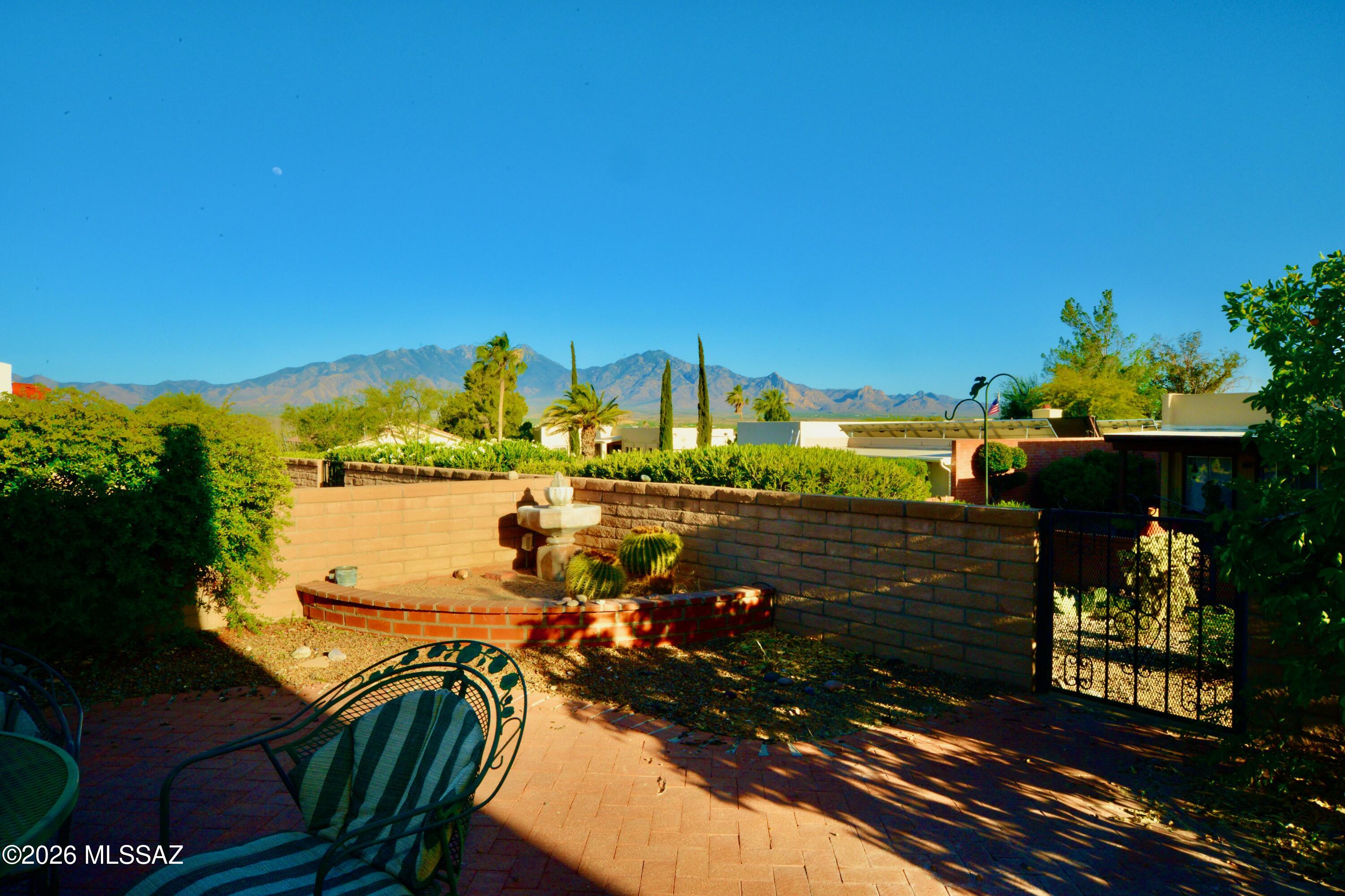 Charming townhome in the sought-after Desert Hills neighborhood with mountain views and inviting indoor-outdoor living. This thoughtfully designed split-bedroom floor plan offers 2 spacious living areas, creating flexibility for relaxing or entertaining. A fantastic paver patio provides the perfect place to unwind and enjoy the stunning light display across the Santa Rita Mountains, while the covered front patio offers a quaint and private welcome home. Inside, rich dark beams, classic slump block construction, and clerestory windows fill the home with warmth, character, and beautiful natural light throughout the day. Ideally located near golf and one of Green Valley Recreation's most popular centers, this home is a wonderful opportunity to enjoy the best of Green Valley 55+ living.
