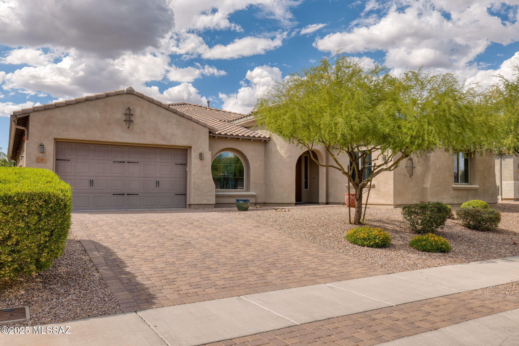 Welcome to 13463 N Trailing Indigo Court, an extraordinary single-level estate in the exclusive gated enclave of Center Pointe Vistoso within the highly sought-after Rancho Vistoso community. This meticulously designed 2017 home offers 3,679 Sq Ft of sophisticated living space, perfectly situated on a premium lot with breathtaking Catalina Mountain views and a serene desert backdrop. Every detail of this residence has been thoughtfully curated, blending modern luxury with timeless elegance to create a home that is as functional as it is spectacular. Step inside to discover soaring ceilings, expansive living spaces, and a flowing open-concept floor plan designed for both grand entertaining and intimate family moments. The gourmet kitchen is a chef's dream, featuring granite countertops, a large center island with seating, 42-inch cabinetry, custom tile backsplash, stainless steel appliances, double ovens, and a five-burner gas cooktop. Adjoining the kitchen, the great room and formal dining area provide an ideal setting for entertaining, enhanced by a 12-foot multi-panel sliding glass door that seamlessly opens to the backyard oasis.

The primary suite is a private sanctuary, boasting a spa-inspired bath with dual vanities, soaking tub, custom tile shower, and an oversized walk-in closet. Each additional bedroom offers ample space, privacy, and designer finishes. A custom-designed interior office elevates the home's functionality, featuring bespoke millwork, built-in countertops, designer paint, and plush carpeting, a refined environment perfect for remote work or study.

The three-car garage is equipped with built-in storage cabinets, offering organized space for vehicles, tools, and hobbies. Outside, the backyard has been transformed into a private resort, featuring a travertine patio, artificial turf, lush gardens, mature trees, and citrus. A custom bar top, built-in gas fire pit, and spa-like hot tub create a seamless environment for entertaining, relaxation, and enjoying the beauty of the surrounding landscape.

Living in Center Pointe Vistoso offers the perfect combination of privacy, security, and community amenities, including scenic walking paths, parks, and ramadas. Beyond the gates, Oro Valley provides an unparalleled quality of life, with top-rated schools in the Amphitheater School District including Painted Sky Elementary, Coronado K-8, and Ironwood Ridge High School. Residents enjoy easy access to world-class shopping and dining at Oro Valley Marketplace, and local boutique eateries. Golf enthusiasts will find premier courses nearby, including Stone Canyon Club, The Views Golf Club, and El Conquistador Country Club, while outdoor adventure awaits at Catalina State Park, Honeybee Canyon trails, and miles of desert hiking and cycling paths.

13463 N Trailing Indigo Court is more than a home,it is a lifestyle. With its meticulous finishes, custom upgrades, and entertainer's backyard, this property offers a rare opportunity to experience luxury living in one of Oro Valley's most prestigious neighborhoods. Every detail has been designed to enhance comfort, elegance, and the enjoyment of Arizona's stunning natural beauty. This is a residence where family, friends, and unforgettable memories converge in perfect harmony.