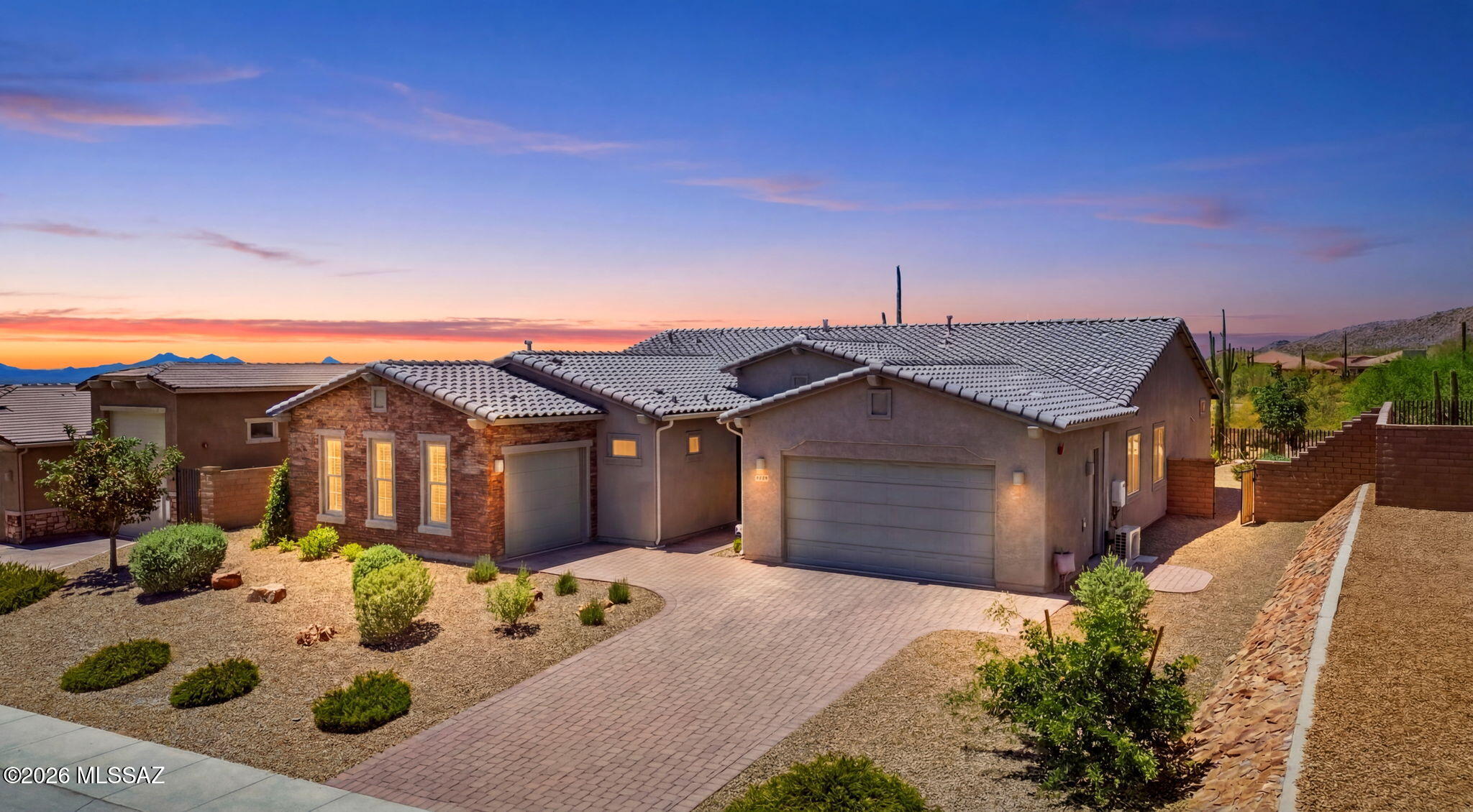 Experience unparalleled flexibility and luxury in this massive, beautifully appointed home located in the highly sought-after community of Marana, Arizona. Perfect for multi-generational living or hosting long-term guests, this unique estate features two completely separate exterior entries. A fully self-contained mother-in-law suite comes complete with its own private kitchen, bathroom, walk-in closet, dedicated patio, and individual entrance. Nestled within an award-winning school district, this home offers the ultimate combination of premium design and functional family layout. The main residence is flooded with natural light, showcasing bright, open bedrooms and expansive living spaces. At the heart of the home is a true chef's kitchen featuring an oversized central island, a built-in pantry, a microwave built in above the oven, and sleek stainless steel appliances--a high-end finish mirrored in the guest suite kitchen as well. The grand master suite provides a daily sanctuary, boasting a spa-like bathroom complete with an attractive, massive walk-in shower, separate vanities, and a dedicated linen closet. In total, the home offers 4 spacious bedrooms and 4 upscale bathrooms. Step out back into your own private desert paradise. The beautifully designed backyard features low-maintenance landscaping, pristine AstroTurf, an elegant water fountain, and expansive modern pavers leading to a premium outdoor kitchen and a charming perched swing. Framed by impressive, mature saguaros and dramatic mountain backdrops, the patio is the ultimate destination to unwind. Enjoy soaking in legendary Southern Arizona sunsets, all while paired with your beverage of choice.