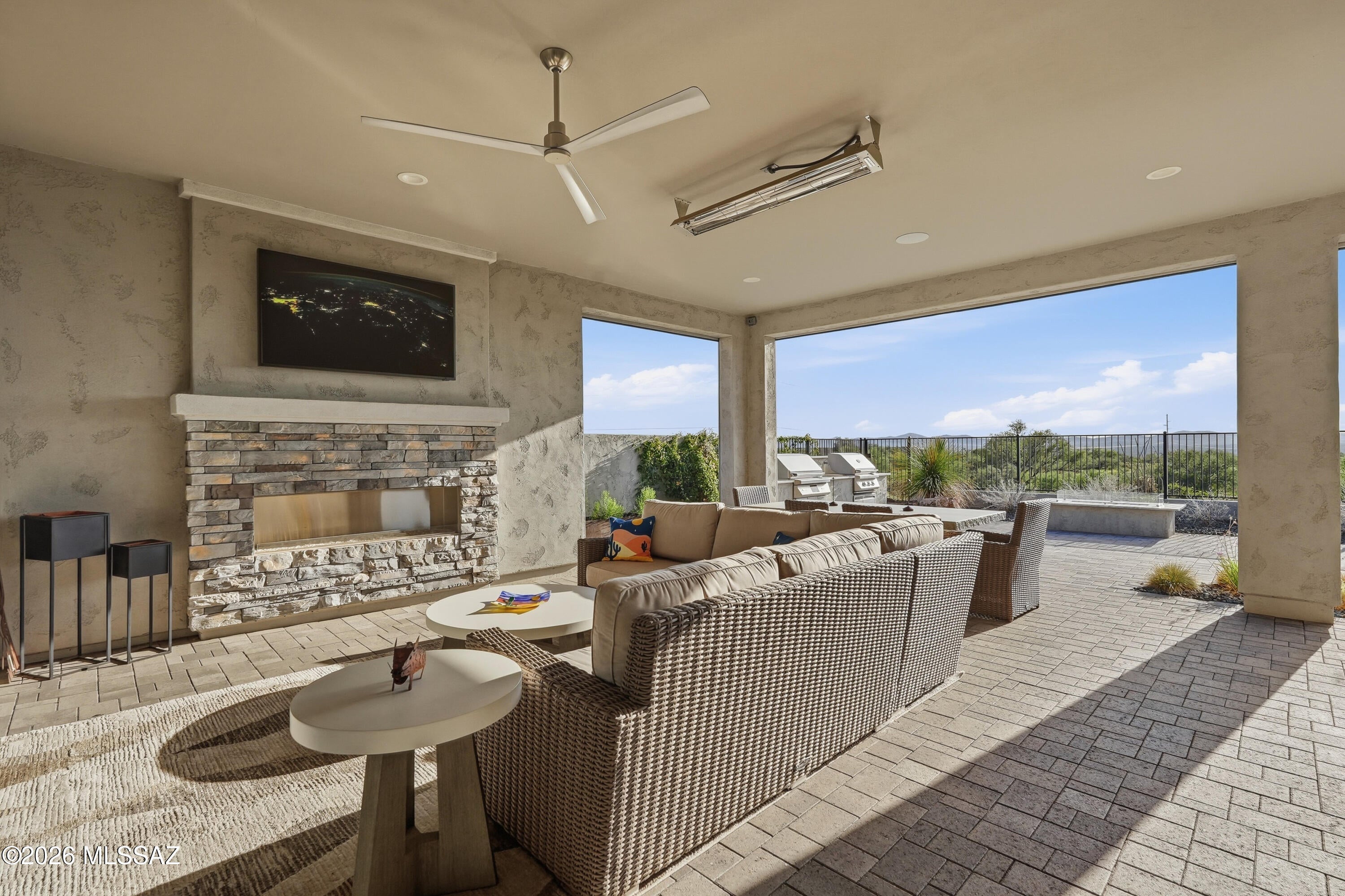 Set against open desert with the Tortolita Mountains filling the horizon, this Avalon is the most significant residence ever offered at SaddleBrooke Ranch - and the moment the iron front door opens, you understand why. A single-slab marble accent wall anchors the great room. A sixteen-foot four-panel glass wall disappears, and there is no line between the coffered-ceiling interior and the desert beyond. Sunset does the rest.

The backyard is built for year-round use. An extended covered patio runs the length of the home. A stone-faced fireplace with TV, a marble-topped firepit, a custom water feature, and a built-in BBQ with high-end smoker, grill, and marble counters. Ceiling speakers overhead, a 61'' Infratech heater for winter evenings, turf, uplighting, a dog run, and a view fence wi a private gate opening onto the desert trails.

Inside, a Crestron system runs lighting, music, cameras, shades and climate by time of day and season - from the wall, your laptop, or your phone, from anywhere in the world. A 400 AMP panel supports it. The LG Signature kitchen carries a six-burner pro cooktop, combination speed oven, 42-inch built-in refrigerator, quartz waterfall island, full-height backsplash, butler's pantry, coffered ceiling, and reverse osmosis. The great room wet bar answers with Zephyr wine fridge and beverage fridge. The dining room wears a split-face white marble wall with lit floating shelves.

The primary suite opens to the patio through a three-panel slider and retreats behind a pocket door to a spa bath: extended curbless shower with custom tile, three shower heads, Toto Neorest toilet, and an extended organized closet. Two guest suites follow suit - custom tiled walk-in showers, marble counters, one with 11' ceilings. A den with a custom mural wall and 85" Sony Bravia TV. A powder room finished like the rest.

The details never lapse: LVP flooring throughout, 5" baseboards, 8' solid-core two-panel doors, two-tone paint, matte black fixtures, upgraded hardware, seamless rain gutters, stone-accented Design D front elevation, pavered driveway and walkway.

The extended three-car garage is climate-controlled by mini-split, epoxy-floored, insulated, and fitted with premium cabinets, workbench, slat wall, overhead racks, Tesla charger, and Kinetico saltless softener behind carriage doors. The extended laundry room includes a custom tiled dog wash with handheld shower, and LG black steel front-loaders on pedestals.

Built to order with roughly one hundred builder options, and finished since with $395,250 in improvements.