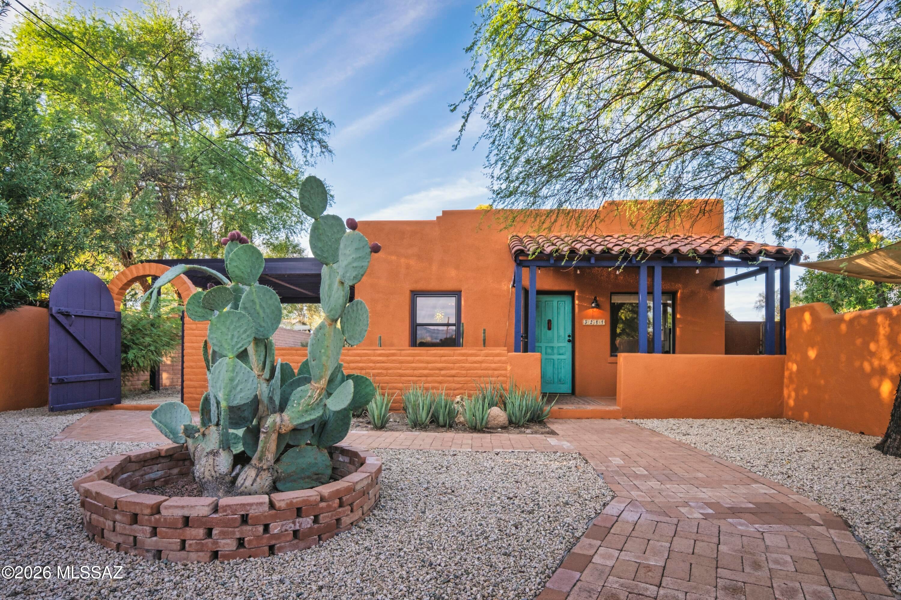 C. 1941 mud-adobe bungalow. An arched gate, richly colored walls and a shaded courtyard introduce you to this home that feels firmly rooted in Tucson. 
 
Exposed beams and Saltillo tile lend warmth, while the 2023 kitchen remodel adds butcher-block counters, open shelving, Talavera tile and a retro refrigerator. A quartz-topped double vanity refreshes the bath. 
 
Windows, a sliding patio door and paint were updated in 2024; new HVAC followed in 2026. Saltillo patios and a side pergola added in 2026 invite morning coffee and afternoons in the shade. 
 
Native pollinator plantings, citrus and raised beds enrich the garden, supported by new irrigation and rock bioswales, all professionally landscaped. A shed with power adds utility and storage. 
 
Unmistakably Tucson.