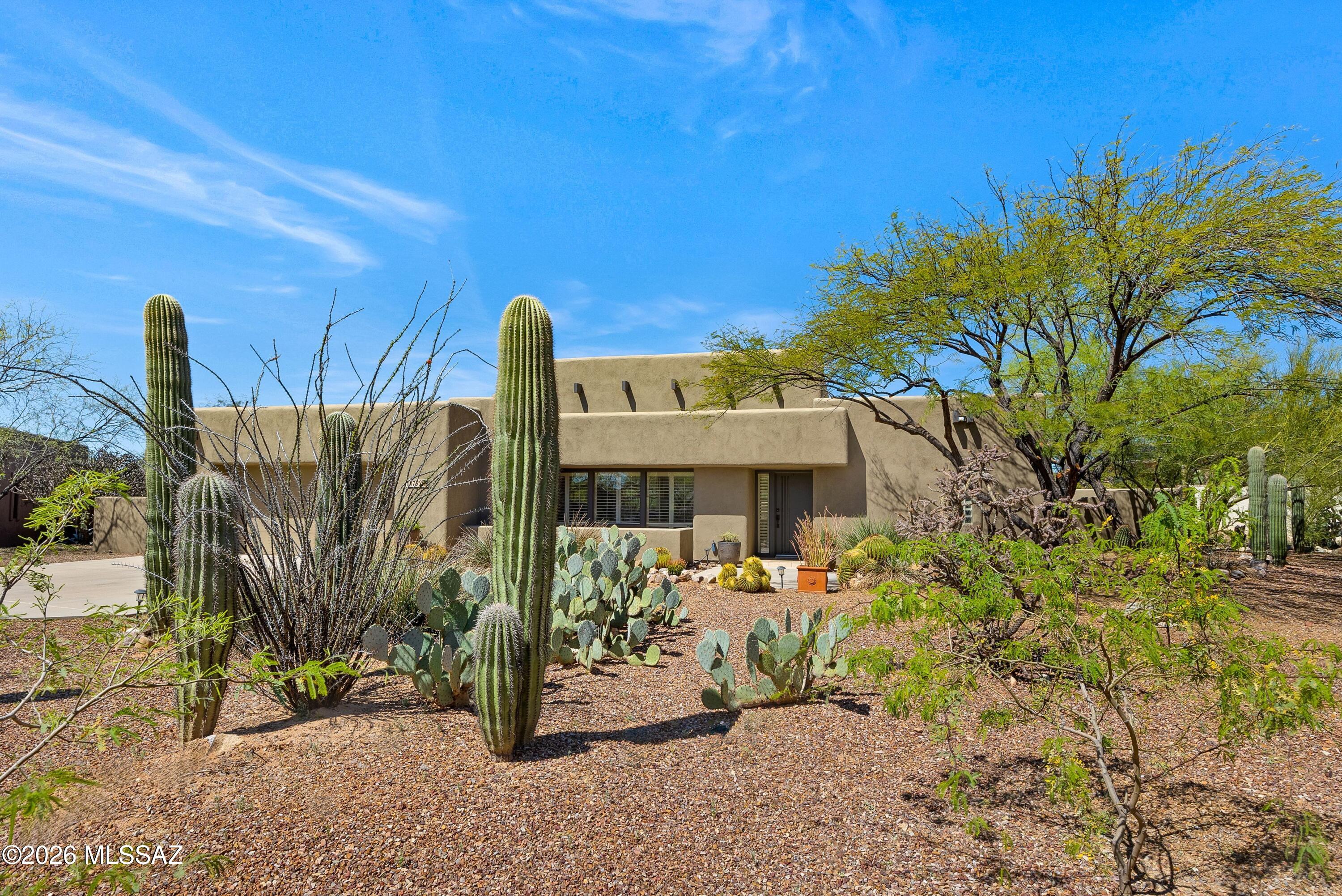Stunning Tyson designed SW Contemporary tucked away in a cul de sac setting. Crisp feel is enhanced by high ceilings, open floor plan, and plantation shutters throughout.  Bedroom 3 currently used as office/library.  Living room focal point is a gas log fireplace, flanked by illuminated niches, and a bold wood beam ceiling accent.  Enjoy the mountain views from the spacious dining room.  Convenient access to the yard from the primary suite. A walk in closet, soak tub, walk in shower, twin sinks set in granite at executive height make this suite special.  Expansive covered patio with extended flagstone patio with bancos and space for your gas BBQ.  View fence offers desert vistas.  Solar panels for energy saving.  Pride of ownership makes this home special