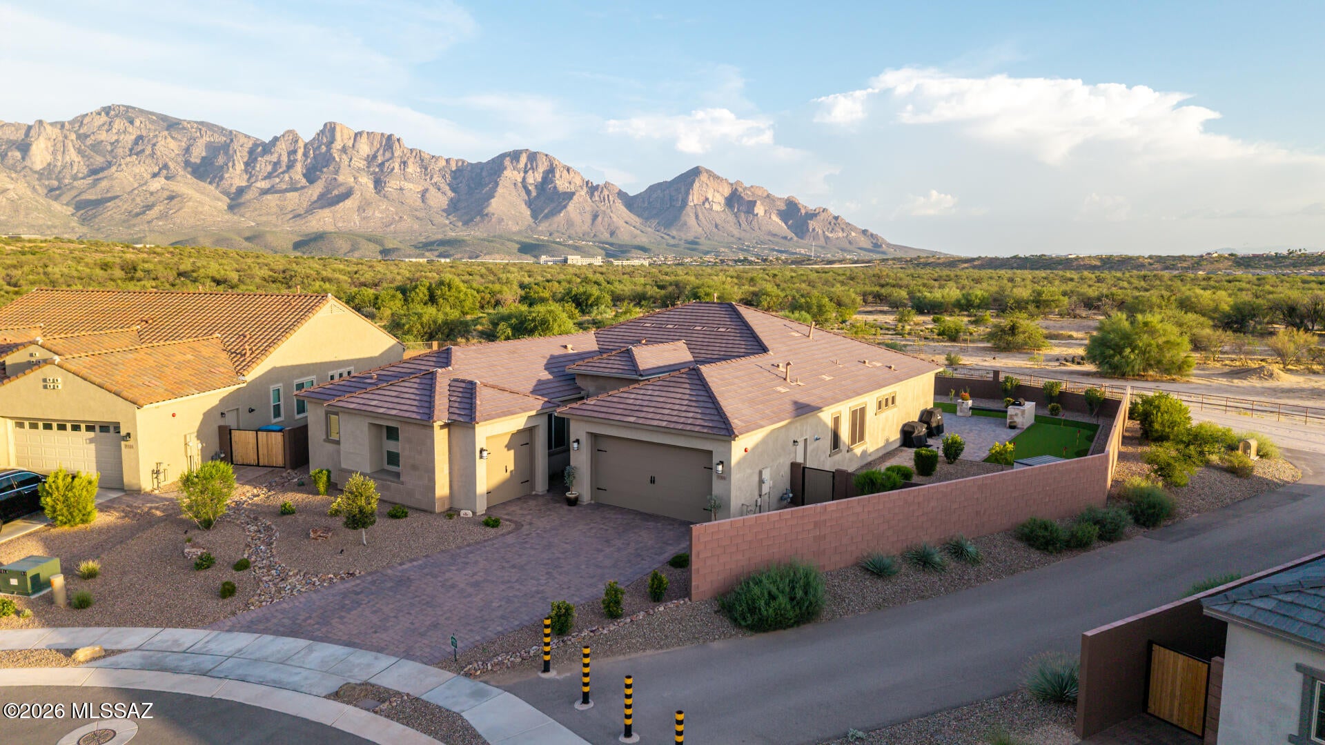 Experience elevated desert living in this beautifully upgraded home, ideally positioned on an oversized lot with mountain views and no neighbors behind you. The stunning gourmet kitchen features an oversized island, custom backsplash, upgraded countertops/cabinetry, premium appliances. Expansive sliding glass doors create a seamless indoor-outdoor connection, showcasing breathtaking views and filling the home with natural light. The spacious floor plan includes an enlarged second suite with a private en-suite bathroom and walk-in closet. Step outside to your private backyard retreat with a built-in outdoor kitchen, cozy fireplace, and putting green, all perfectly positioned to enjoy the views and ultimate privacy. Premium upgrades include finished garage floors and high-end finishes.
