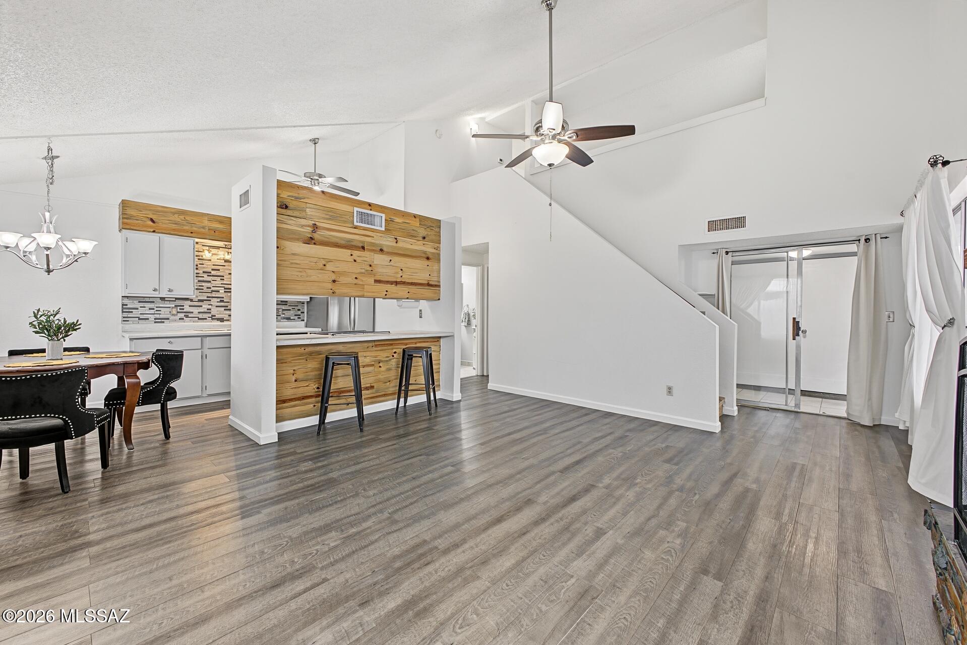 Beautifully updated 2-bedroom, 2-bath townhome blending character, comfort, and move-in-ready appeal! Fresh interior paint and wood flooring complement soaring ceilings, natural light, and a striking stone-surround fireplace. The kitchen features newer stainless steel appliances, white cabinetry, a mosaic tile backsplash, and a pass-through to the living area. A charming dining nook with a distinctive round window adds architectural interest. Updated bathrooms and a newer A/C enhance everyday comfort. Enjoy your private backyard, ideal for morning coffee or relaxing evenings. Conveniently located near shopping, dining, and everyday amenities. Schedule your showing today!