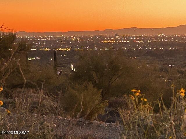 When the lights ''come on'' in the city ♫ (sorry, Journey), enjoy dramatic SWEEPING nighttime views of the ENTIRE TUCSON VALLEY. This 1+ acre, near-flat ridge-top homesite is in coveted Quail Canyon Ridges and SURROUNDED by million-dollar homes in a luxurious GATED ENCLAVE of only 27 homesites.   High profile lot with an EVER-CHANGING BACKDROP by day and night - wake up to SUNRISES and unwind on the patio as the Sonoran Desert delivers its LEGENDARY SUNSETS. And don't forget the views of FIVE mountain ranges - Catalina, Rincon, Santa Rita, Tucson Mtns and Green Valley's Sierrita Mtns.  YOUR BUILDER WILL APPLAUD YOU for finding such gentle topography allowing for a more efficient and economical build that FOCUSES MORE ON DESIGN AND LIFESTYLE. North property line is about 225'from the