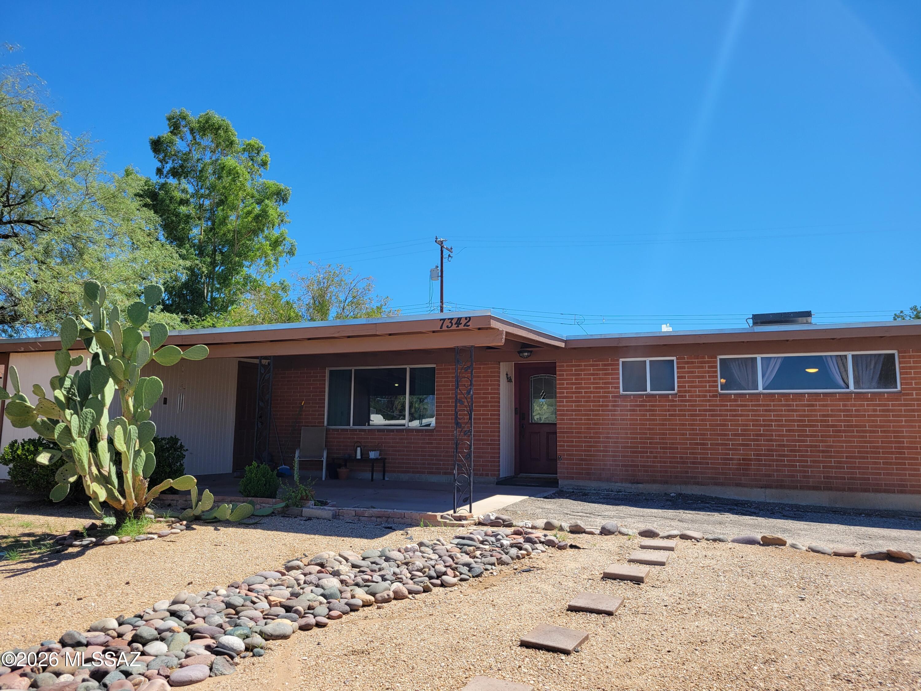 Timeless mid-century classic nestled in East Tucson. This 3 bedroom, 2 bath home offers 1,158 square feet of comfortable living space with an open floor plan and a recently updated air conditioning system. One bedroom has been thoughtfully transformed into a library, creating a unique space for reading, working or relaxing. Dark, modern interior finishes add a bold contemporary feel while complementing the homes classic character. With durable brick construction, no HOA and plenty of mid-century charm, this home is ready to welcome it's next owner!