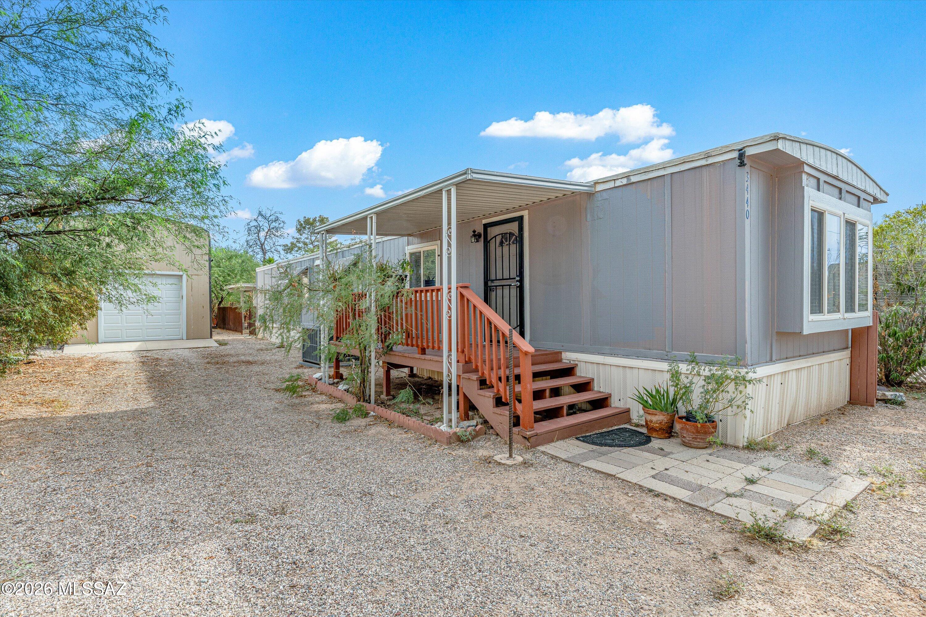 Welcome home to this well-maintained 3-bedroom, 1.5-bath manufactured home in a convenient central location! The home features vinyl flooring, granite countertops in the kitchen and bathrooms, an electric water heater, and an all-electric heat pump/AC system installed approximately six years ago. The interior was also painted within the past few years, offering a clean and updated feel. Outside, enjoy a private backyard with a gazebo and additional storage shed. The enclosed 14x50 garage provides flexible space for parking, a workshop, or storage. An additional RV port/workshop has separate water and electric meters, with potential to connect to sewer and create an additional living space or unit. With versatile spaces and plenty of possibilities, this property is ready for its next owner