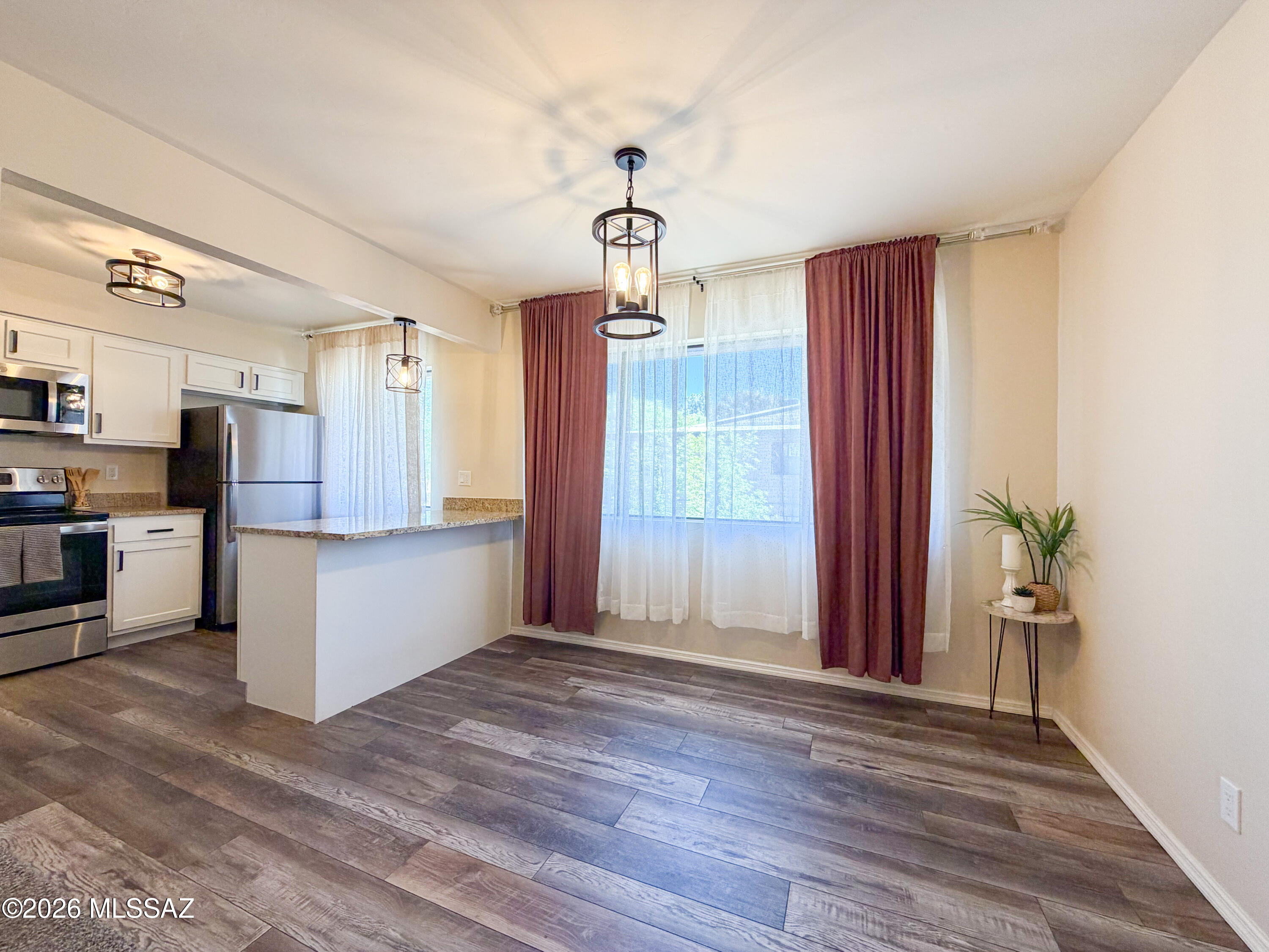 Nestled within a lush, park-like setting surrounded by towering palms, evergreens & citrus trees, this charming co-op offers easy living right in the heart of everything. Enjoy peaceful walking trails, relaxing benches, playgrounds, basketball courts & vibrant community center featuring a sparkling lap pool, soothing spa, shaded Ramadas & BBQ areas. The community is pet-friendly w/ convenient clean-up stations, spacious laundry facilities, and ample guest parking. Inside, discover thoughtful designer touches throughout from crystal-tipped curtain rods and stylish lighting to upgraded plumbing fixtures & modern finishes. The well designed kitchen boasts white shaker cabinets, granite countertops, stainless steel appliances & an island perfect for meal prep or casual dining. The bath features new Vykrell surrounds & sleek new tub for easy cleaning. A flexible bonus room offers endless possibilities as a home office, fitness area, or even a chic dressing room. Wood-look vinyl flooring & carpet create a warm & inviting atmosphere, while the new Goettl HVAC system and newer water heater add comfort & peace of mind.  Ideally located near shopping, restaurants, grocery stores, entertainment, gyms, bus routes & the University of Arizona--this home blends modern upgrades w/ unbeatable convenience.