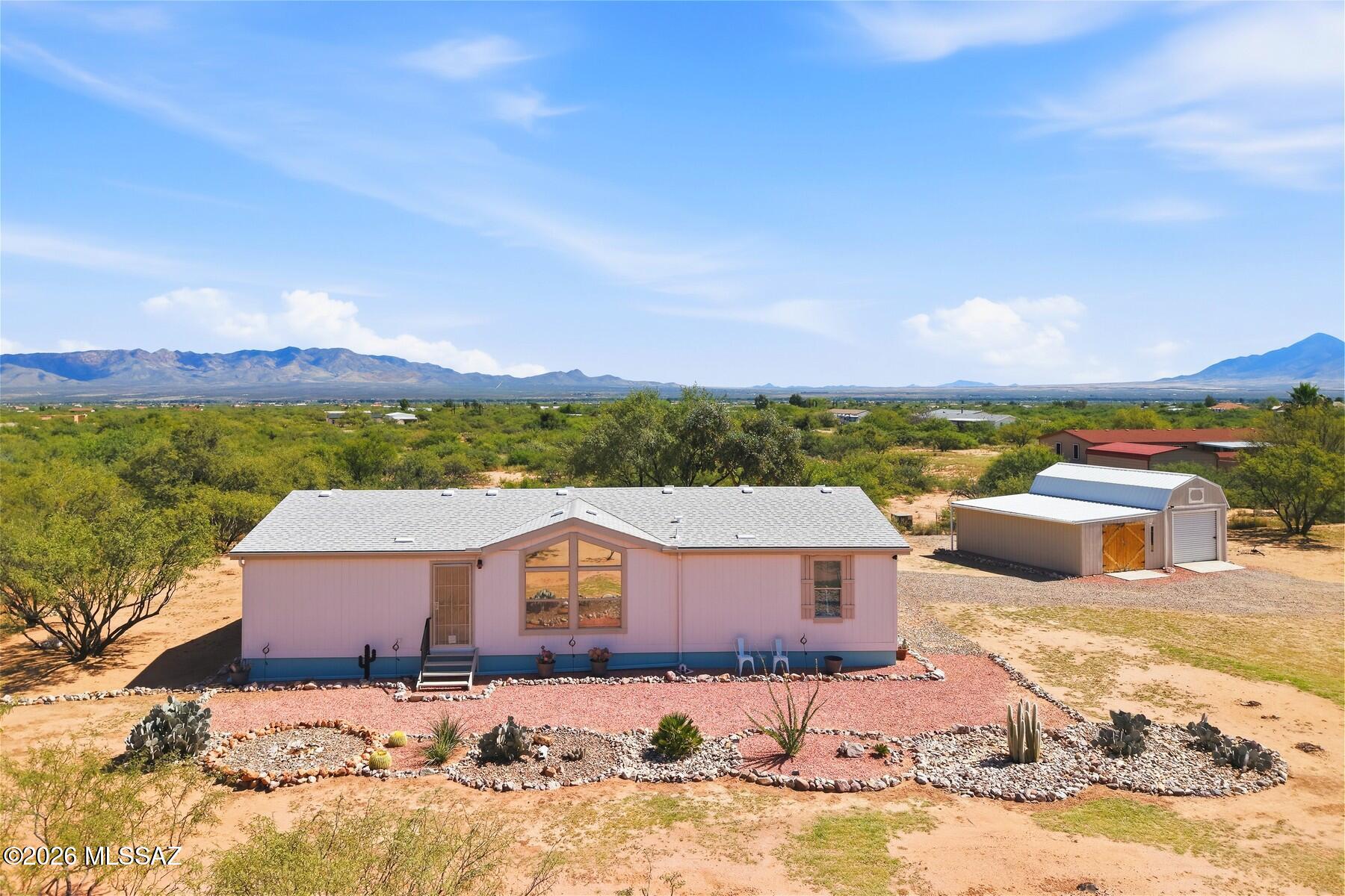 FANTASTIC 3BR/2BA, 1,922 SF manufactured home in Hereford on over 4 fully fenced acres with STUNNING panoramic mountain views! This well-maintained, all-electric home features an open, airy split floor plan, spacious rooms & abundant storage. Beautiful kitchen remodeled in 2024 w/knotty pine cabinetry, stainless appliances & eat-in dining overlooking the outdoors through French doors. Huge primary suite offers vaulted ceiling, generous closet space & updated ensuite bath (2026). New flooring, AC & furnace in 2021. The roof is just 8 yrs old! Enjoy a relaxing outdoor oasis w/covered deck & gated ramp, 12x24 double-loft barn plus 15x24 insulated shop w/AC & electric. 5-well share, septic risers, double-entry gate, long drive & tons of RV/toy parking. Easy paved-road access & VIEWS GALORE!