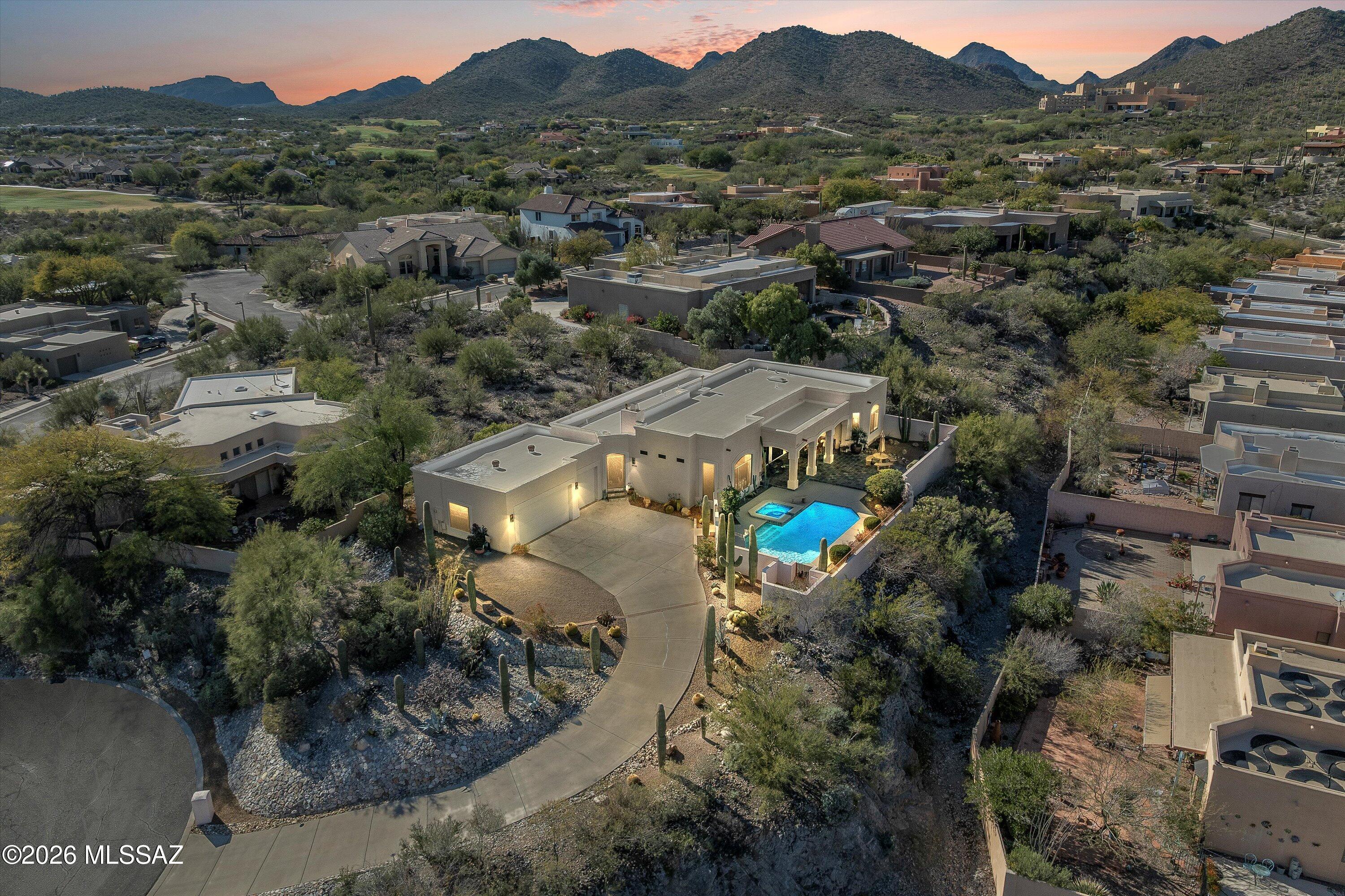 Crowning a private ridge at the end of a cul-de-sac, this exceptional single-story Starr Pass estate commands one of the community's most coveted positions. Offering 3 bedrooms, 3 bathrooms, and 2,589 square feet of thoughtfully designed living space, the home delivers the complete Arizona luxury lifestyle—unobstructed 270-degree mountain views spanning the Santa Catalinas, Rincons, and Tucson Mountains, golf course frontage, and resort-level outdoor living with remarkable privacy.

The arrival sets the tone as a gracefully elongated private drive ascends to the summit, where the entire Tucson basin unfolds below. This elevated cul-de-sac position eliminates through-traffic, while Arnold Palmer-designed golf course frontage provides a permanent greenbelt buffer— ensuring views that can never be compromised. No homes above. No future development to interrupt the horizon. This is finite, irreplaceable positioning.
Resort-level outdoor living designed for everyday enjoyment anchors the experience. A conventionally heated pool sized for true recreation is paired with a spa ideal for evening relaxation beneath star-filled skies and glowing city lights. A substantial covered patio provides year-round usability, capturing cooling mountain breezes while offering shelter from sun and monsoon weather. Mature desert landscaping frames each vantage point with established, low-maintenance beauty.
Inside, oversized windows and high ceilings flood the home with natural light, allowing the surrounding mountains to become living art throughout the day. Porcelain tile flooring delivers the warmth of Saltillo with modern durability. The great room is anchored by an authentic kiva-style gas fireplace with custom built-ins, creating a natural gathering space that reflects the home's Contemporary Santa Fe architecture and seamless indoor-outdoor flow.
The kitchen is designed for both elevated daily living and effortless entertaining, featuring granite countertops, a custom tile backsplash with diamond accents, professional-grade cooktop, and abundant cabinetry. A standout butler's pantry with wet bar, sink, extensive storage, and second refrigerator provides ideal separation for hostingkeeping prep, service, and cleanup discreet and efficient. Kitchen windows frame sweeping Tucson Mountain views.
The split-bedroom floor plan offers exceptional privacy. The primary suite occupies its own wing, showcasing breathtaking Santa Catalina Mountain views and a spa-inspired bath with dual vanities, separate toilet area, and walk-in closet with built-in organization. Two guest bedrooms are thoughtfully positioned on the opposite side of the home.
Additional features include a full laundry room conveniently accessed through the primary suite, and a three-car garage finished with premium polyaspartic flooring, delivering a clean, showroom-quality space.
The intangibles complete the experience: elevated ridge-top living, dramatic monsoon skies, daily wildlife sightings, unforgettable sunsets, and city lights stretching across the valley below. Morning coffee with mountain sunrise. Evenings with desert twilight and alpenglow.
End-of-cul-de-sac, ridge-top homes offering panoramic multi-mountain views, golf course frontage, and resort-level outdoor living are exceedingly rare. When they become available, they are immediately recognized.
Located minutes from the JW Marriott Starr Pass Resort & Spa, residents enjoy proximity to world-class dining, spa services, golf, tennis, and fitness amenitieswithout the obligations of resort living. Tucson Mountain Park trails and Saguaro National Park West are just moments away.
This is more than a homeit's a lifestyle defined by elevation, views, and timeless desert elegance.