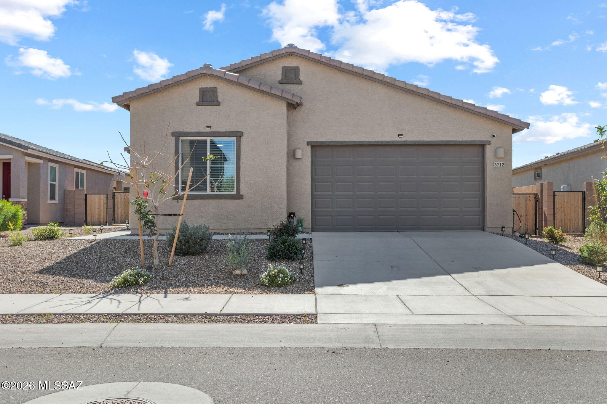 Located in the desirable La Estancia master-planned community and within the top-rated Vail School District, this 2024 single-story home blends modern style with thoughtful upgrades. Residents enjoy exceptional amenities including parks, playgrounds, sports courts, two community pools with splash pads, and direct access to The Loop, Tucson's 120-mile paved biking and walking network.

This 1,930 sq ft home, completed in September 2024, offers 3 bedrooms, 2 bathrooms, a versatile flex room, and a two-car garage with an EV charging port. Built-in features include the Taexx pest-control system, gas tankless water heater, electric A/C, and gas heating. A wide range of upgrades enhances comfort and convenience: a fully landscaped low-maintenance backyard with pavers and irrigation, solar lighting, smart ceiling fans throughout, motorized patio shades, blinds on all windows, a water softener, security cameras and sensors integrated with ADT/Google Home (all equipment paid off), and a smart front door lock. The gourmet kitchen features a stacked oven/microwave, gas cooktop, and vent hood. The primary suite includes a walk-in shower with hand shower and accessibility grab bars and GFCI outlets in bathrooms for electrical bidets.

The home is offered partially furnished, including power-reclining living room seating, a complete king bedroom set, and a furnished office with a height-adjustable desk. Outdoor extras include multiple bird feeders in the front and backyard.

This newly built residence captures the essence of modern desert living, perfectly positioned just minutes from everyday conveniences, grocery stores, shopping, dining, entertainment, medical facilities, and surrounded by the breathtaking beauty of the Sonoran landscape. It's a home you're sure to fall in love with.