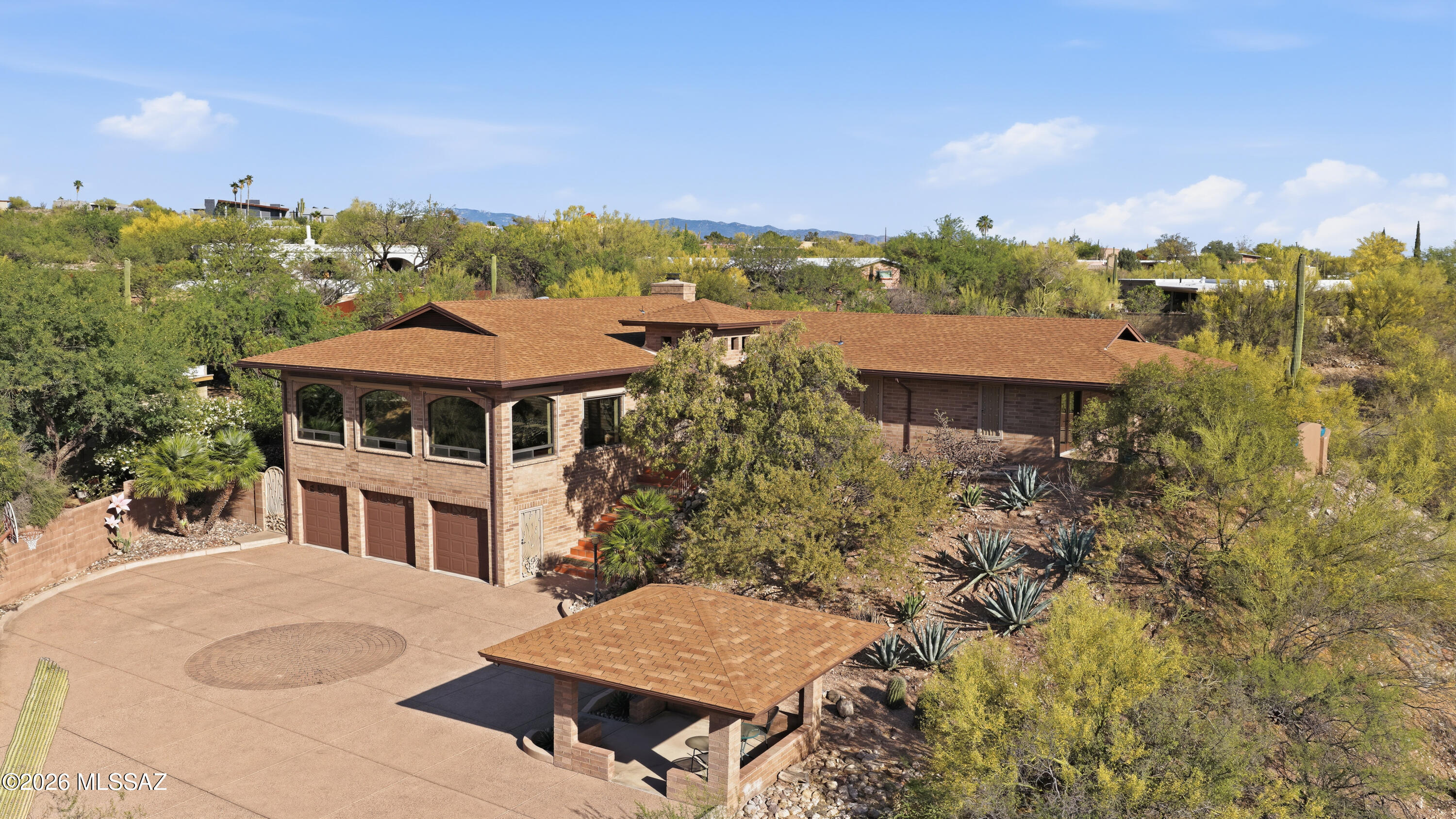 Perched in the coveted Catalina Foothills, this exceptional Tucson residence offers a rare blend of refined luxury, privacy, and breathtaking natural beauty. Showcasing sweeping 360-degree views of the surrounding mountains and sparkling city lights, this home is a true desert retreat designed for both relaxation and elevated entertaining.

Thoughtfully positioned above the surrounding landscape, the home's elevated main living spaces are designed to maximize privacy while capturing the spectacular vistas that define Foothills living. The result is a peaceful, retreat-like atmosphere where stunning views become part of everyday life.

This thoughtfully designed home features 3 spacious bedrooms and 2 beautifully appointed bathrooms, along with a rare and expansive 3.5-car garage --perfect for car enthusiasts, storage, or a home workshop.

Inside, timeless elegance meets modern comfort with rich wood flooring, cool travertine tile, and thoughtfully curated finishes throughout. The gourmet kitchen is a chef's dream, showcasing stunning granite countertops, expansive prep space, and a seamless connection to the home's main living areas, complete with a well-appointed wet bar featuring a granite sink--perfectly designed for elevated entertaining.

The primary suite is a private sanctuary, complete with its own patio overlooking the city, where a cozy gas fire pit and tranquil fountain create the perfect setting for morning coffee or evening unwinding under the stars. From this serene vantage point, enjoy captivating views of iconic Sentinel Peak, adding a distinctive Tucson backdrop to your everyday retreat.

The front courtyard offers a charming and private welcome, featuring a beautiful gazebo perfectly positioned to capture up-close, unobstructed views of the Catalina Mountains, including Finger Rock--an ideal setting for quiet mornings or sunset gatherings.

Step outside to experience resort-style living at its finest. The expansive outdoor space is designed for entertaining, with a sparkling pool, a fully equipped barbecue and bar area, and multiple patios that capture Tucson's iconic sunsets and panoramic vistas. A striking waterfall feature welcomes you at the front entry, setting the tone for the serene ambiance found throughout the property.

Additional features include security roller shades for enhanced privacy, peace of mind, and energy efficiency, as well as a whole-home generator--an exceptional convenience that provides uninterrupted comfort and confidence by keeping essential systems operational during unexpected power outages.

This is more than a home--it's a lifestyle defined by luxury, privacy, spectacular views, and the timeless beauty of the Sonoran Desert.