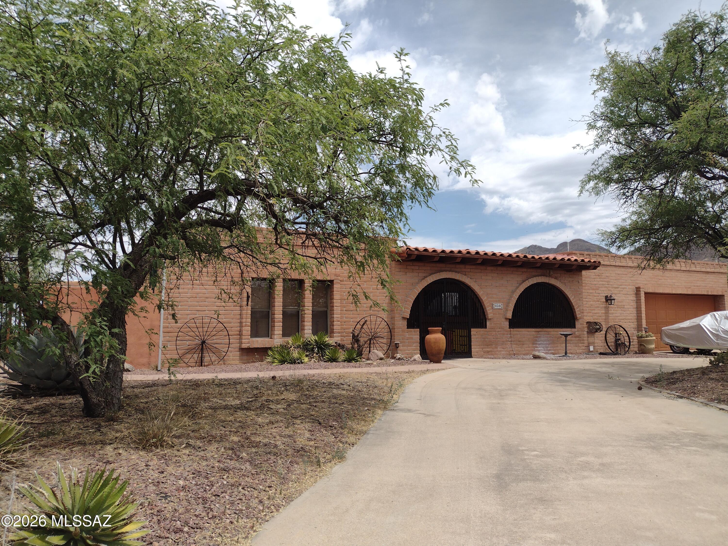 Mountain views and stunning Arizona sunsets surround this private retreat on nearly 2 acres! This spacious brick home offers timeless curb appeal with low-maintenance durability and a peaceful setting perfect for relaxing or entertaining. The kitchen features custom hickory cabinets, tile countertops, stainless steel appliances, and a built-in trash compactor, opening to a cozy family room with fireplace. Large-format tile flooring and ceiling fans throughout provide year-round comfort. Expansive Arizona room with swamp cooler adds flexible living space. Roof recently recoated with 2-year warranty. Oversized 2-car garage offers abundant storage/workspace plus RV parking and extra parking. Large patio, charming front porch, and spacious side yards complete this classic Arizona retreat!