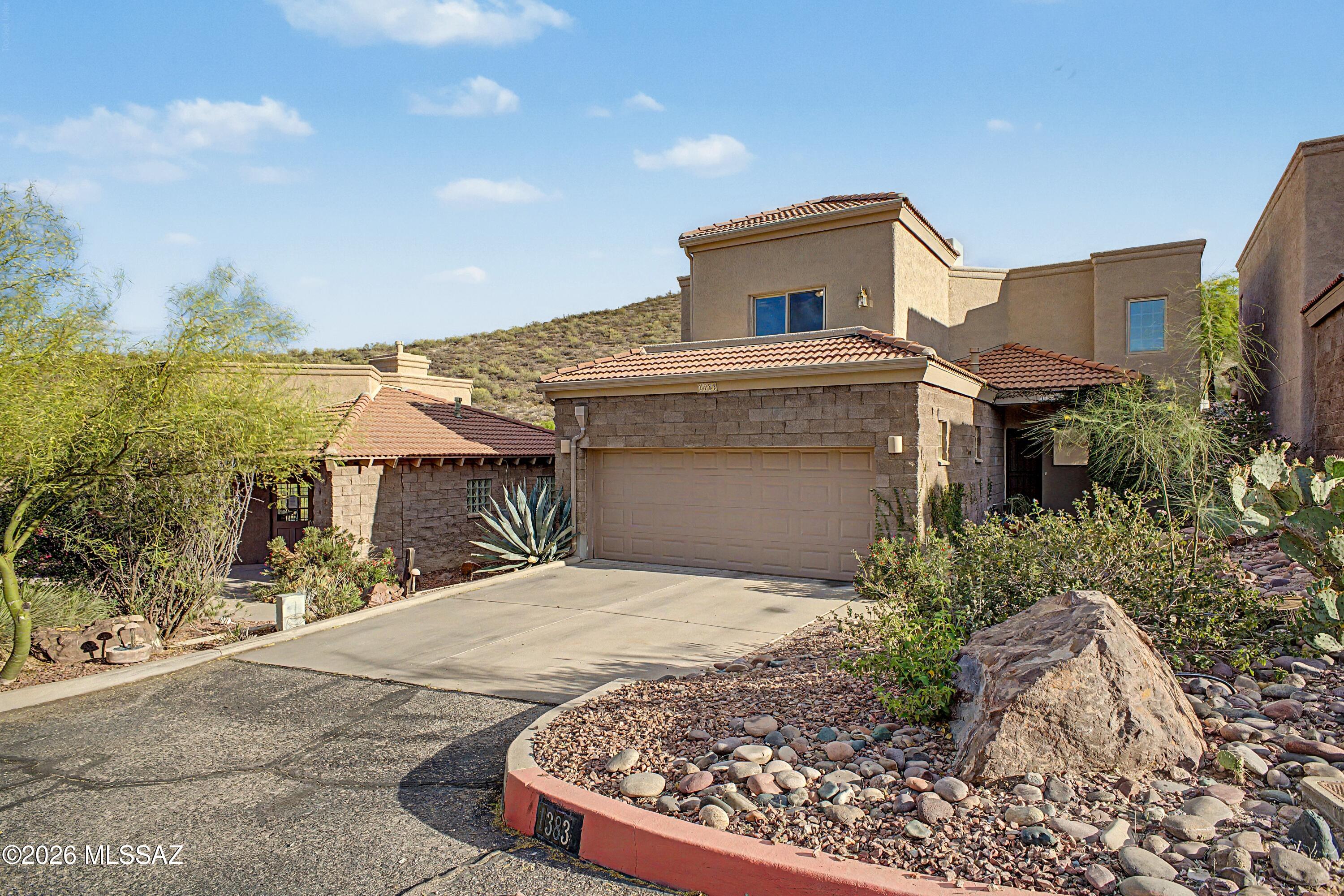 MOTIVATED SELLERS! This lovely 3-bedroom home in Sentinel Shadows welcomes you with a 2-car garage, a charming desert landscape, and a stunning stone facade. Fall in love with the captivating living room with soaring ceilings, skylights for abundant natural light, and rustic wood flooring. The gourmet kitchen comes with granite counters, ample wood cabinetry, recessed lighting, SS appliances, a walk-in pantry. Double doors lead to the main bedroom downstairs that lead to the backyard, a private bathroom, and a walk-in closet. Upstairs, you'll find a second primary bedroom with a cedar closet and ensuite bathroom. Enjoy a picturesque backdrop from the balcony, featuring sweeping mountain scenery and vibrant city-skyline views.  A versatile loft which includes a wet bar, and a third bedroom. Imagine enchanting sunsets in the backyard, which offers a spacious patio, perfect for dining al fresco or weekend grills. Make this incredible gem yours! This home is also wired for sound!