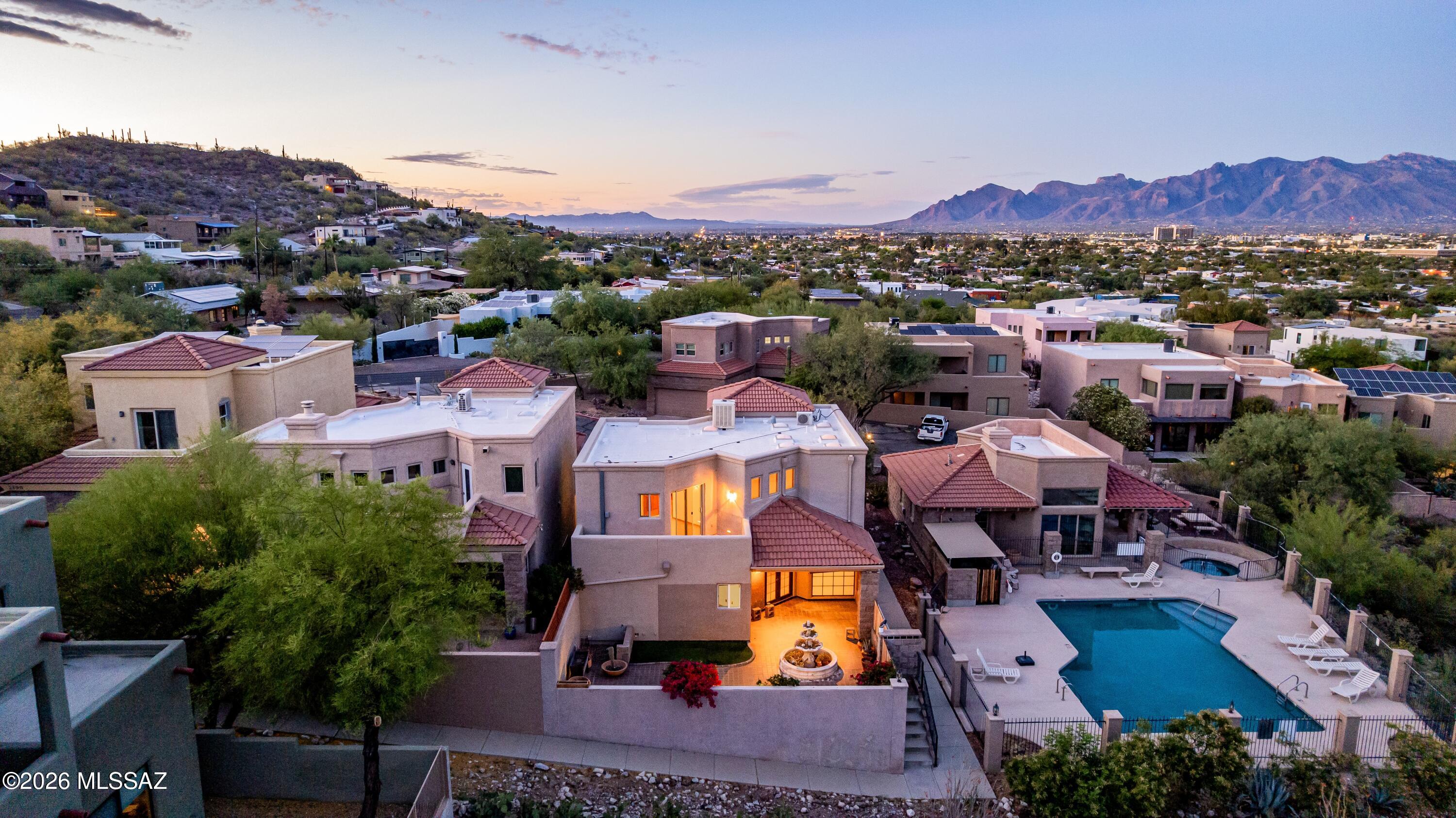 MOTIVATED SELLERS! This lovely 3-bedroom home in Sentinel Shadows welcomes you with a 2-car garage, a charming desert landscape, and a stunning stone facade. Fall in love with the captivating living room with soaring ceilings, skylights for abundant natural light, and rustic wood flooring. The gourmet kitchen comes with granite counters, ample wood cabinetry, recessed lighting, SS appliances, a walk-in pantry. Double doors lead to the main bedroom downstairs that lead to the backyard, a private bathroom, and a walk-in closet. Upstairs, you'll find a second primary bedroom with a cedar closet and ensuite bathroom. Enjoy a picturesque backdrop from the balcony, featuring sweeping mountain scenery and vibrant city-skyline views.  A versatile loft which includes a wet bar, and a third bedroom. Imagine enchanting sunsets in the backyard, which offers a spacious patio, perfect for dining al fresco or weekend grills. Make this incredible gem yours! This home is also wired for sound!