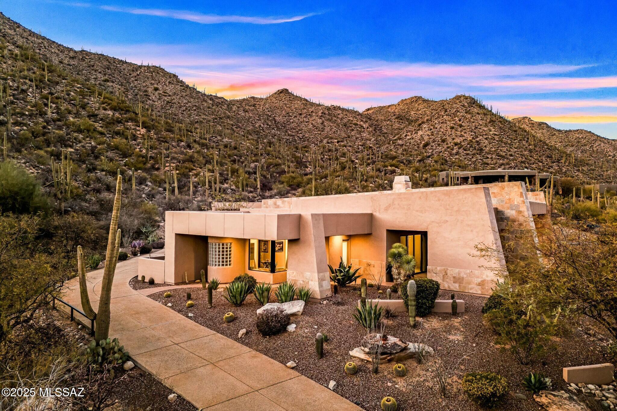 Nestled within the prestigious gated community of Canyon Pass in Dove Mountain, this exquisite 5,743 sq. ft. estate seamlessly blends luxury, comfort, and functionality. Designed with soaring ceilings and an open-concept great room, the home offers a grand yet inviting atmosphere. The spacious kitchen is a chef's dream, featuring newer appliances, a separate island with a prep sink, and a bright eat-in area. Each of the four bedrooms is a private ensuite, complete with built-in desk space, ensuring both convenience and privacy. A generously sized theater/media/rec room with a wet bar provides the perfect space for entertainment and relaxation. The oversized laundry room, equipped with extensive cabinetry, counters, and a sink add to the home's practicality. Step outside and embrace the beauty of desert living. Multiple covered patios offer breathtaking mountain views in both the front and back, while the resort-style saltwater pool and spa provide a tranquil escape, complete with a dedicated outdoor bath for added convenience. An outdoor kitchen and built-in fireplace create the perfect setting for entertaining under the stars.  A spacious four-car garage with epoxy floors and ample storage provides plenty of room for vehicles and recreational gear.   Located in the heart of Dove Mountain, this estate offers both serenity and accessibility. Enjoy world-class golf courses, fitness center, and an exclusive clubhouse-membership optional. Surrounded by natural beauty and set in a peaceful environment, this home is a rare gem in the Sonoran Desert.